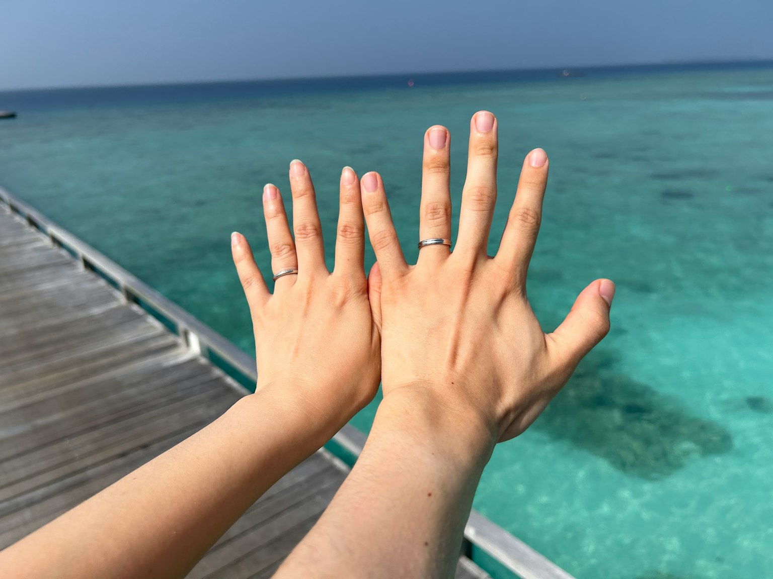 Two hands together near the ocean