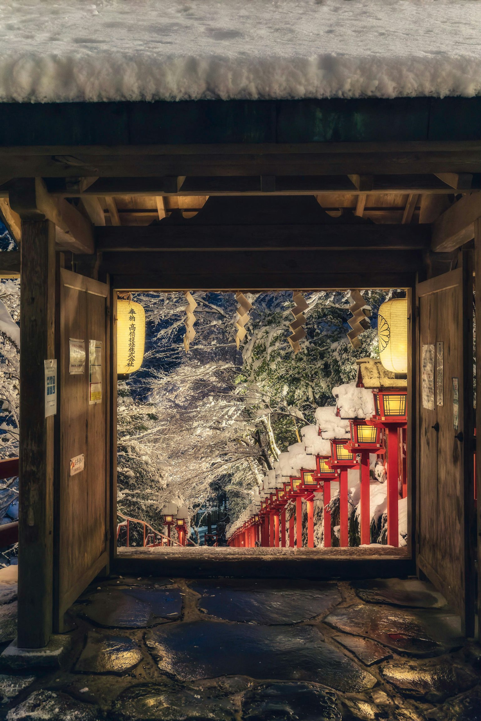 Entrée d'un sanctuaire avec des marches rouges couvertes de neige