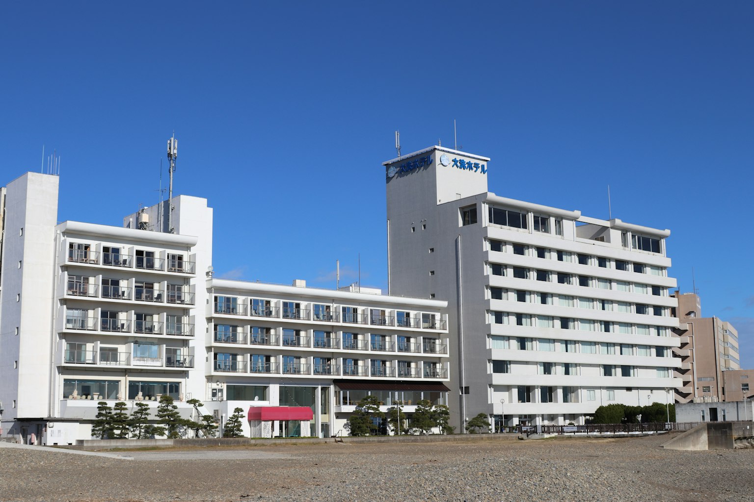 A white hotel building under a clear blue sky