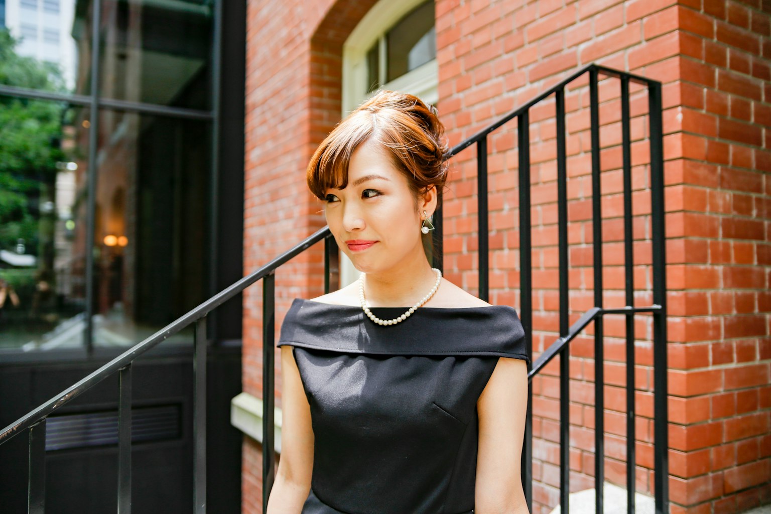 穿着黑色裙子的女人站在砖墙前