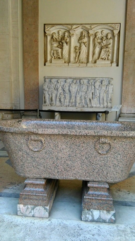 fontaine en pierre avec bas-reliefs sculptés dans une cour