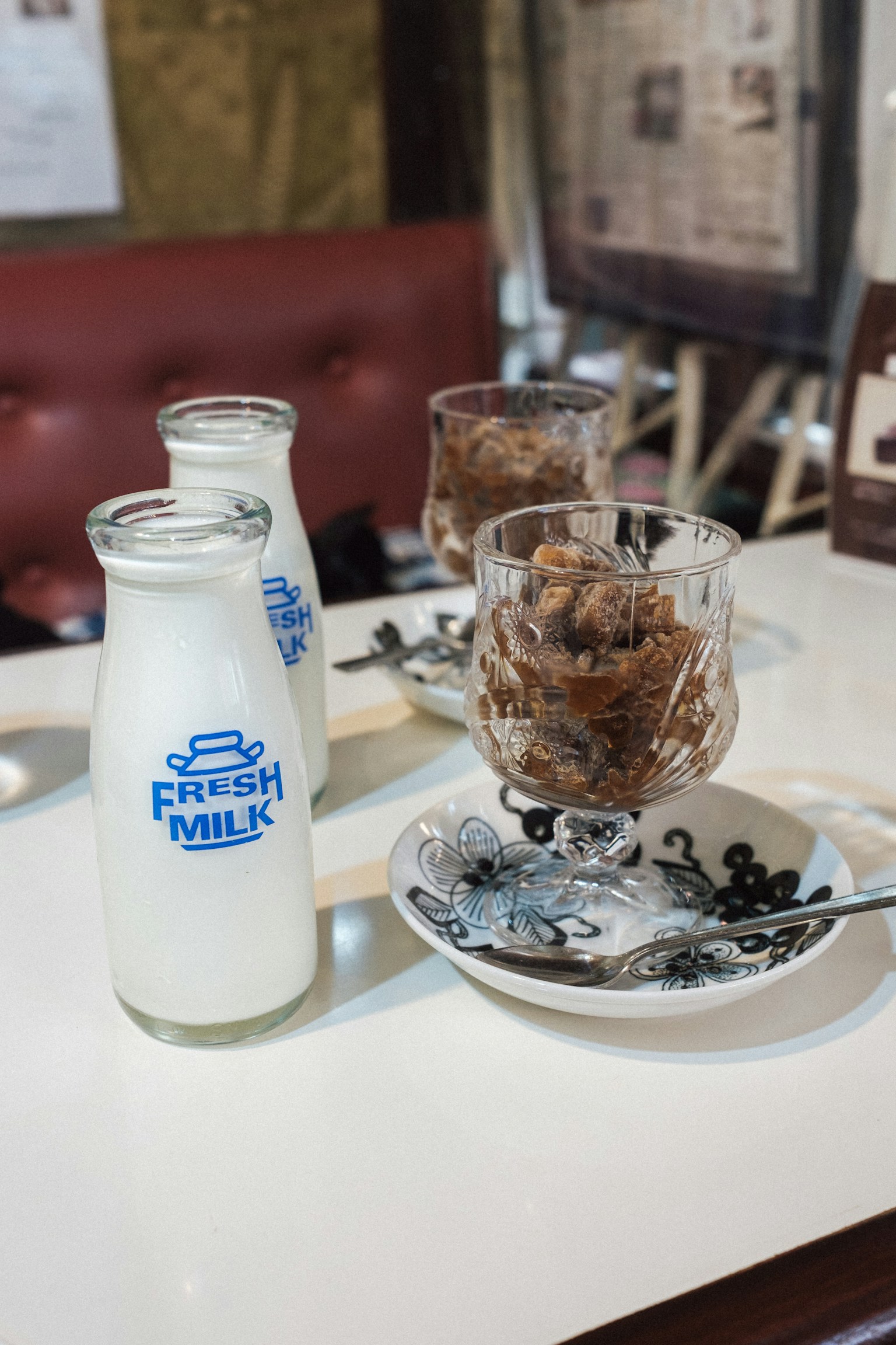 Ein Cafétisch mit einer Flasche frischer Milch und einem Schokoladendessert in einem Glas