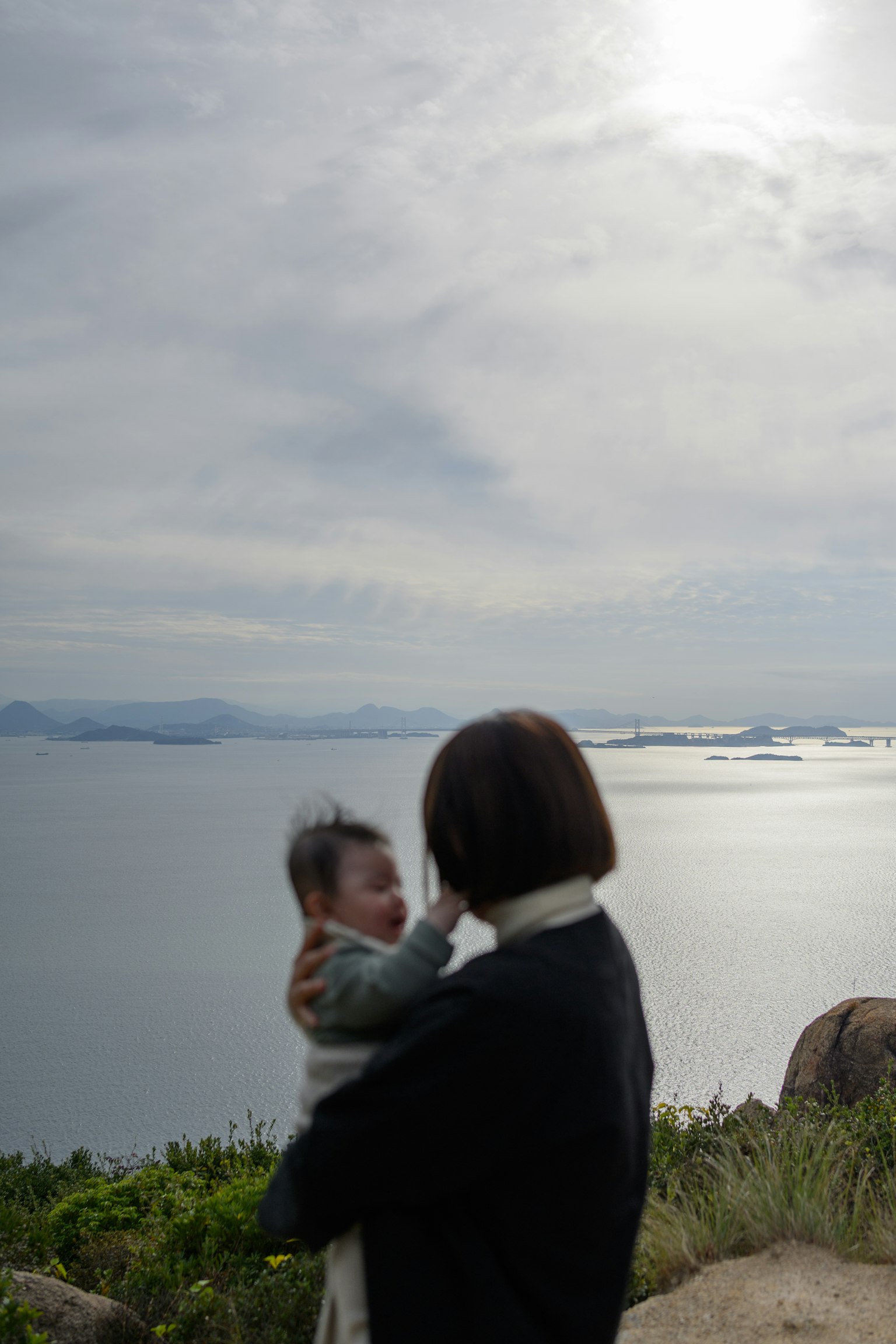 海を背景にした母親と赤ちゃんのシルエット