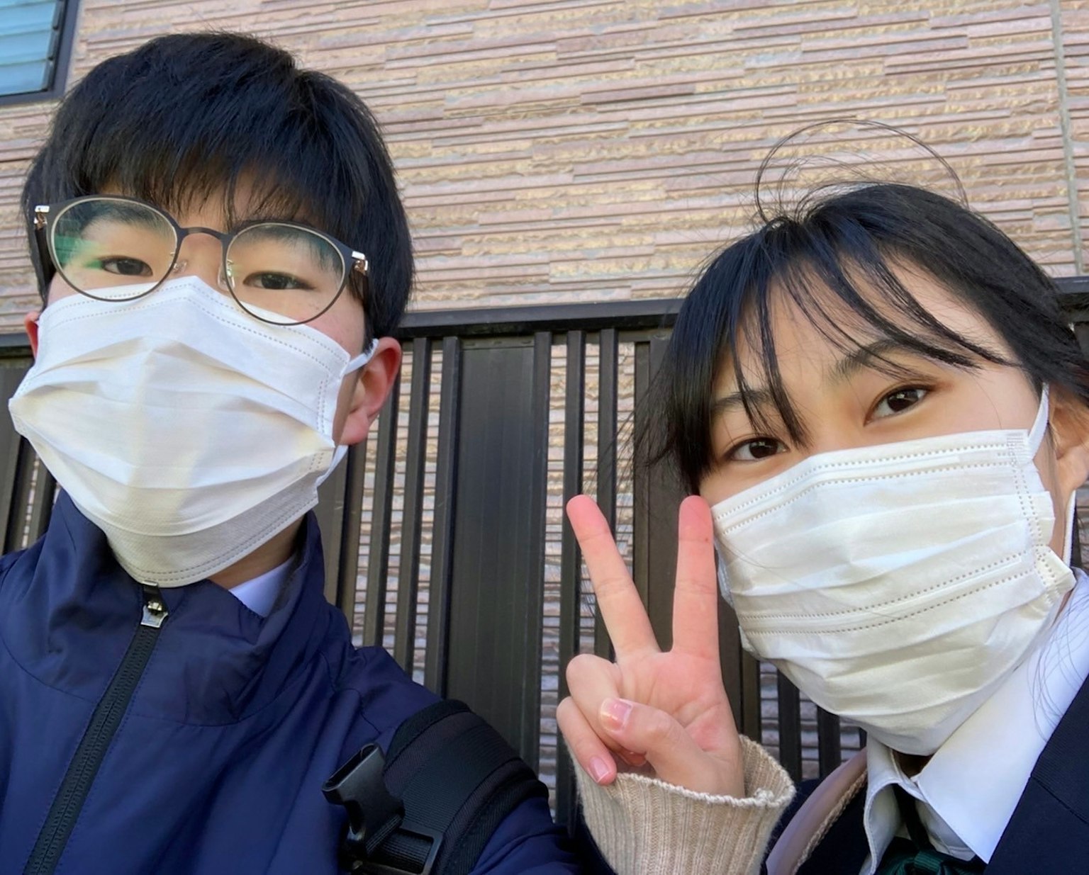 Dua siswa mengenakan masker tersenyum dan berpose untuk selfie