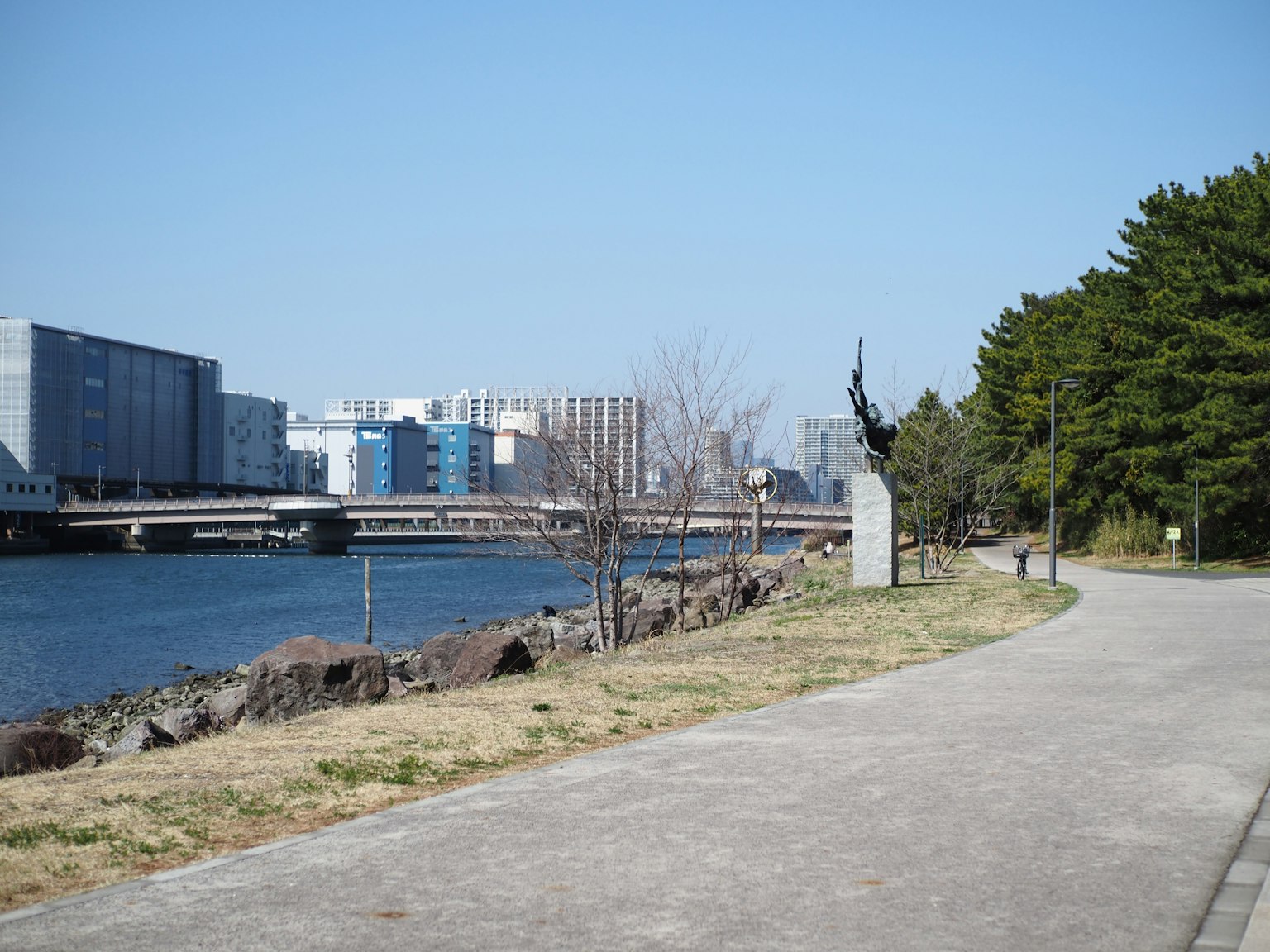 Paesaggio urbano con un sentiero lungo il fiume e un monumento