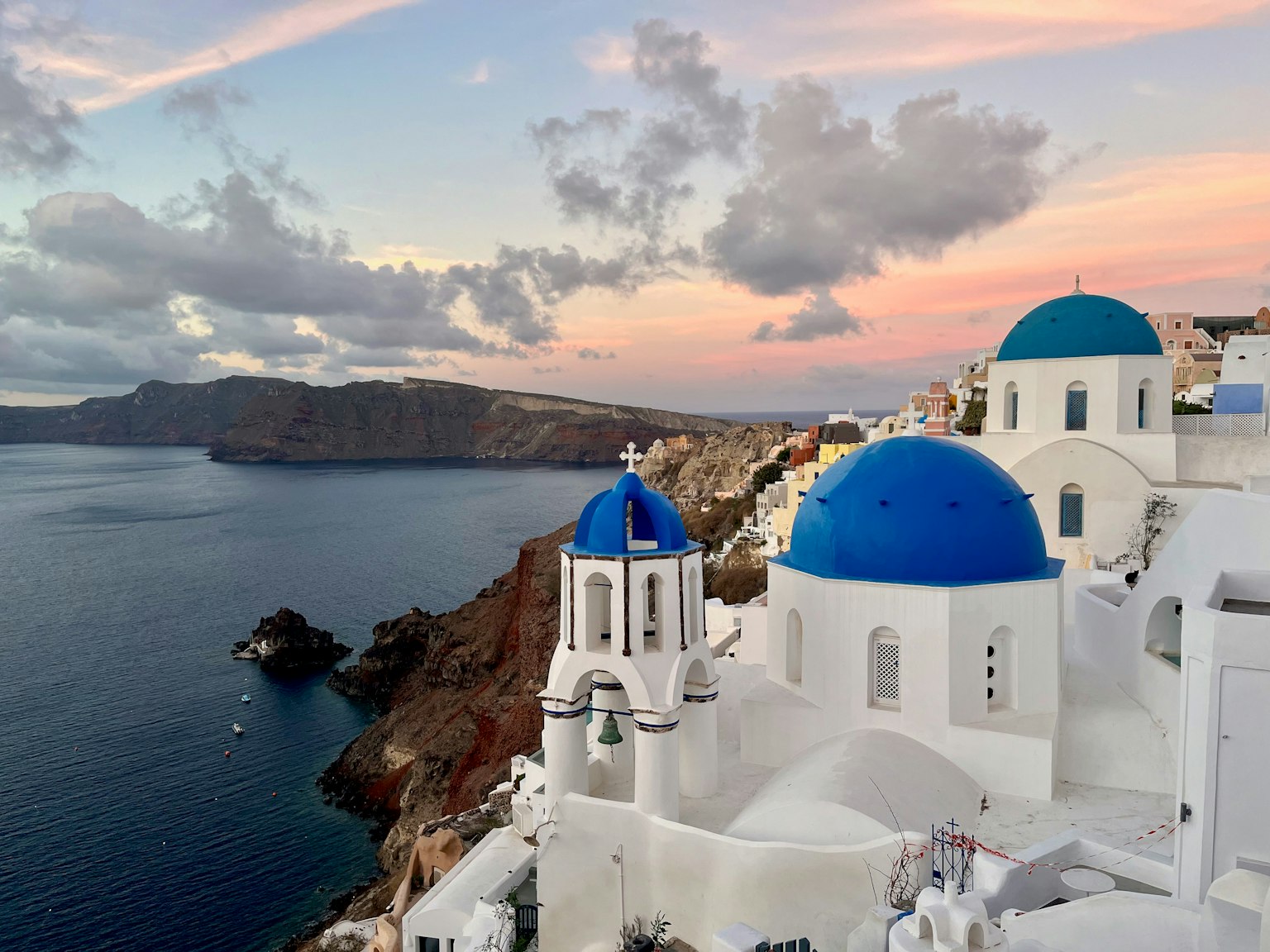 Cảnh biển Santorini với những mái vòm xanh và tòa nhà màu trắng