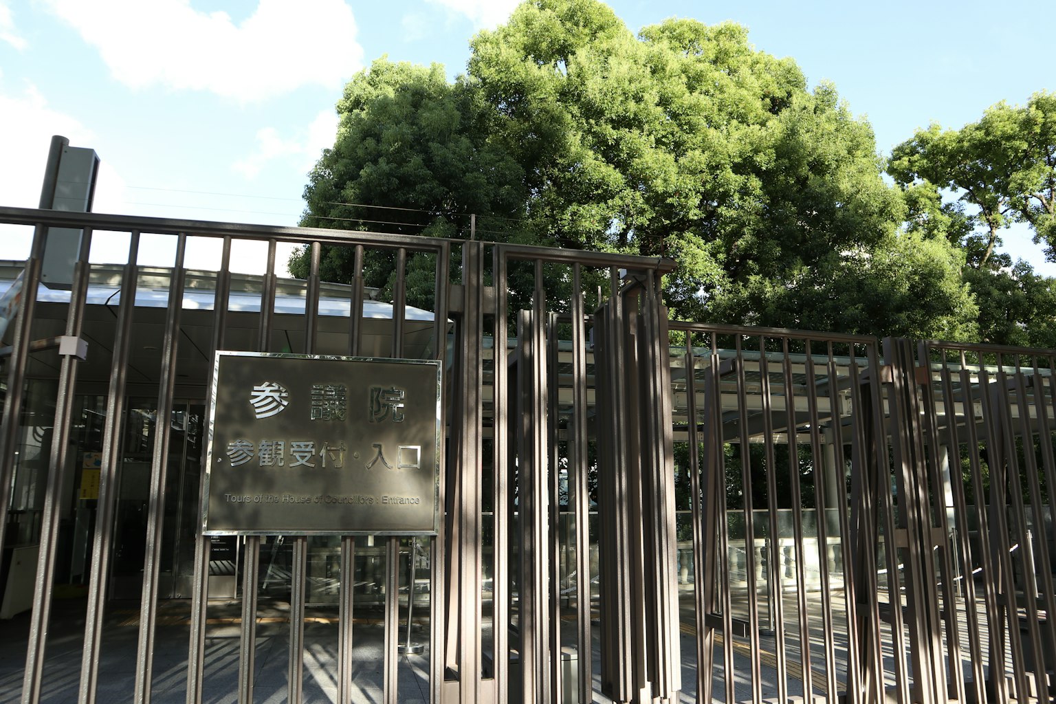 公園入口，特色是黑色圍籬和一棵大樹