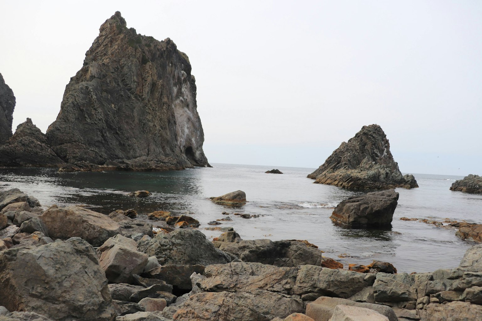 Küstenlandschaft mit Felsformationen und ruhigem Meer
