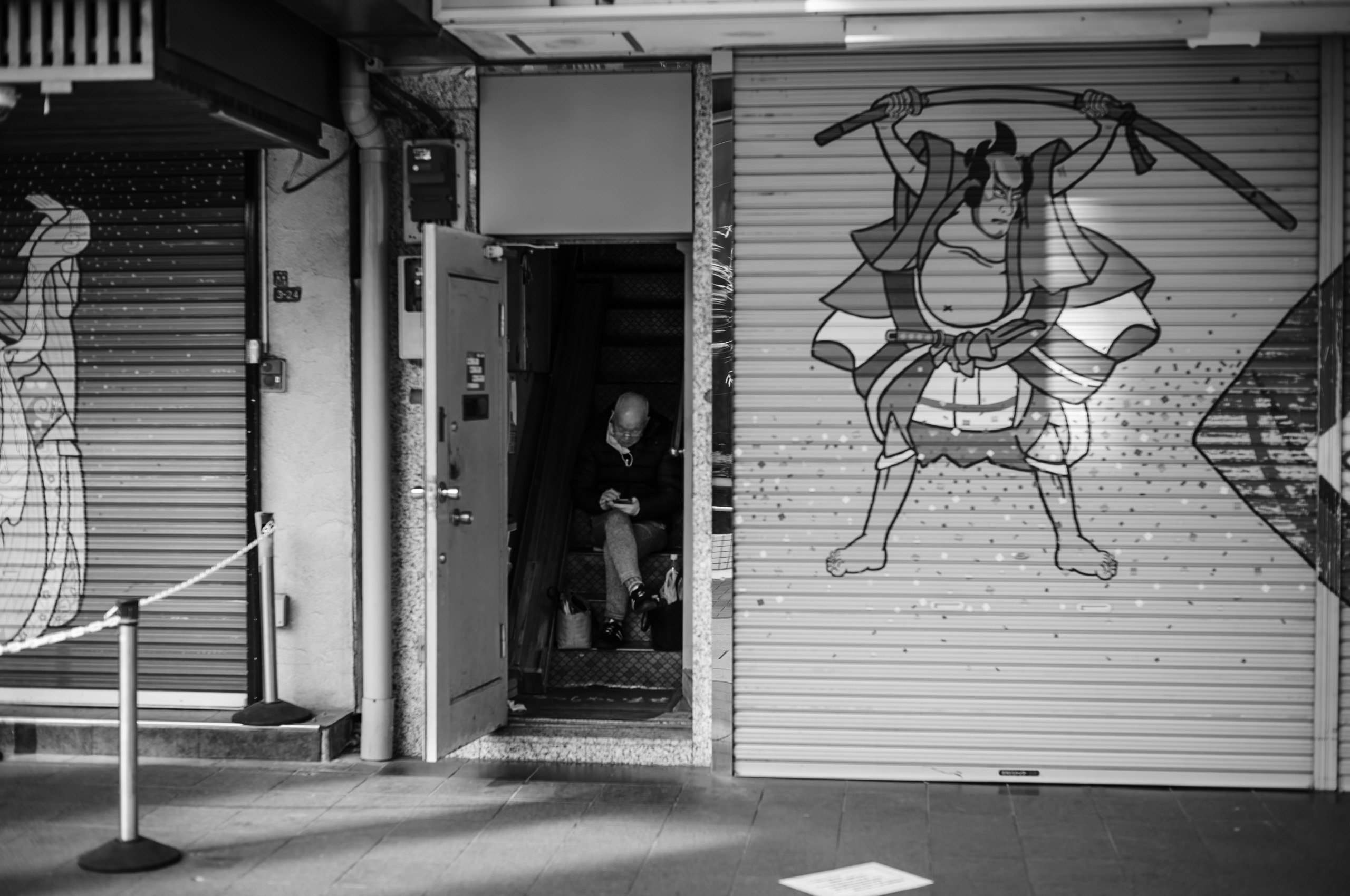 シャッター通りの路地にある壁のアートと人物