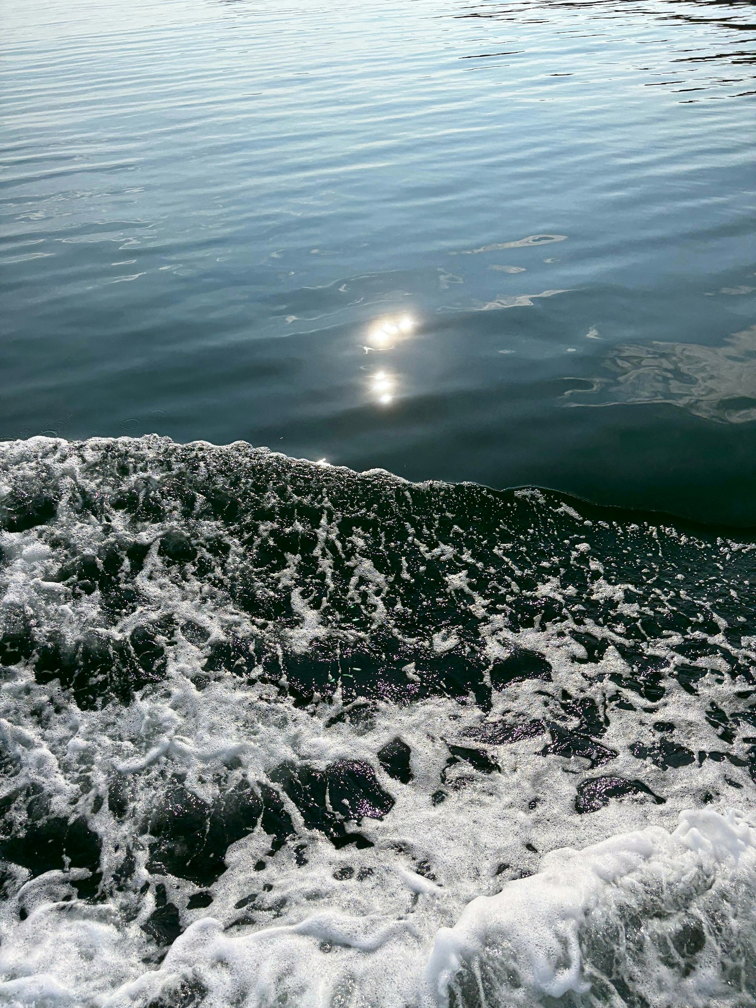 Riflesso della luce solare sull'acqua calma con onde