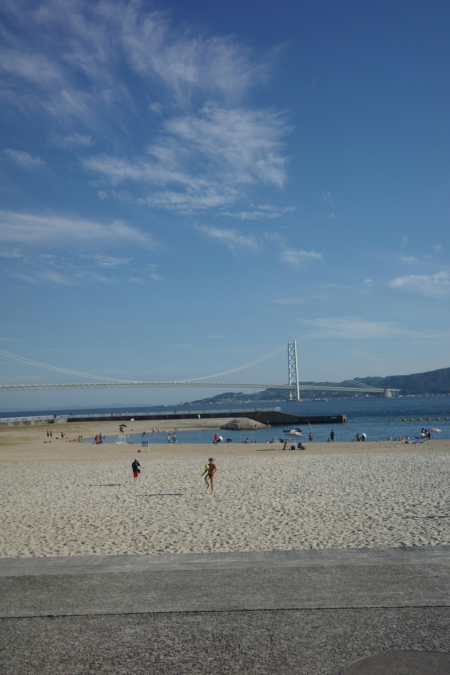 Scena di spiaggia con ponte cielo blu e sabbia bianca persone che camminano