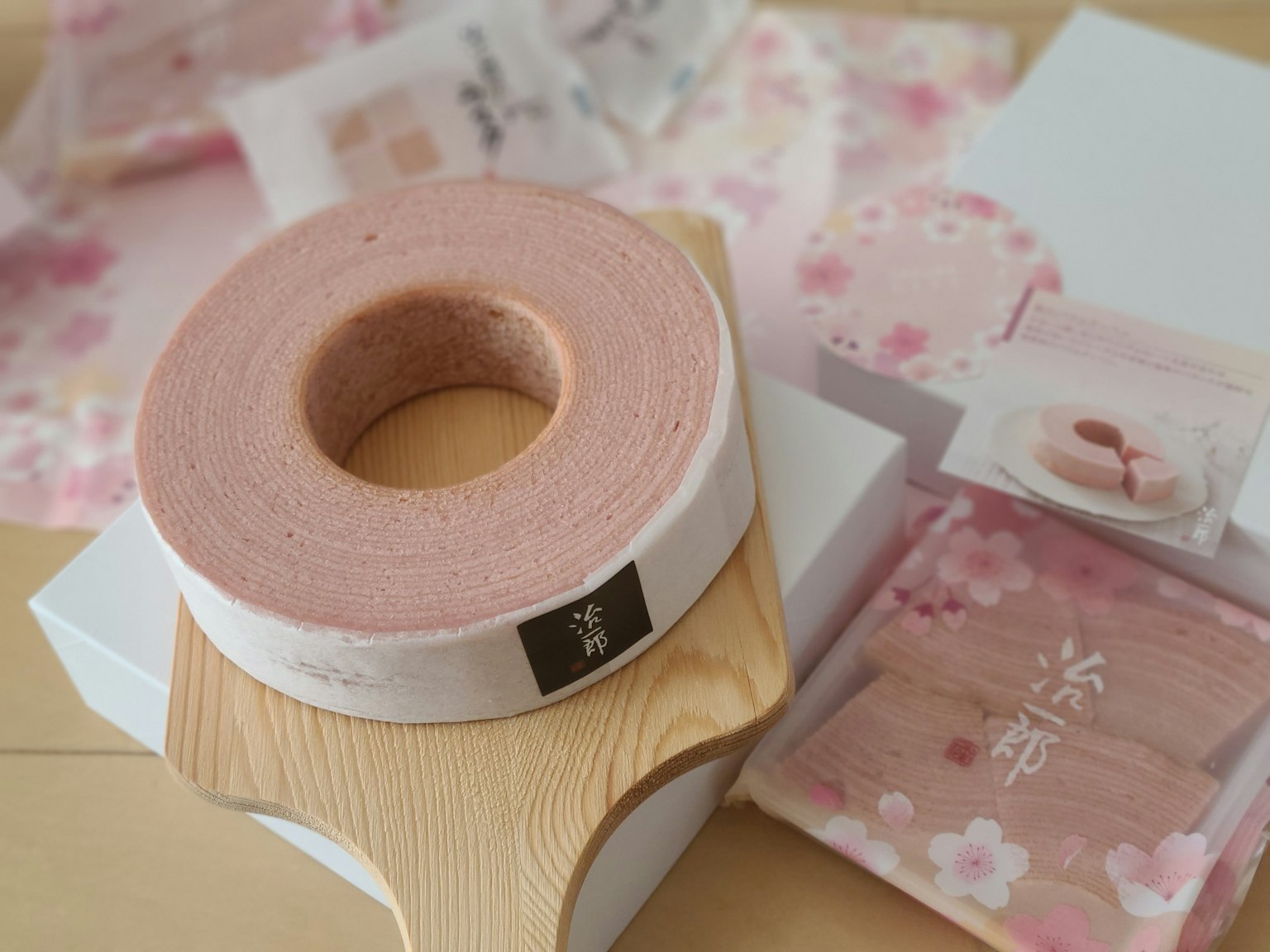 Una escena serena con una cinta rosa y papeles de regalo con diseño de flores de cerezo
