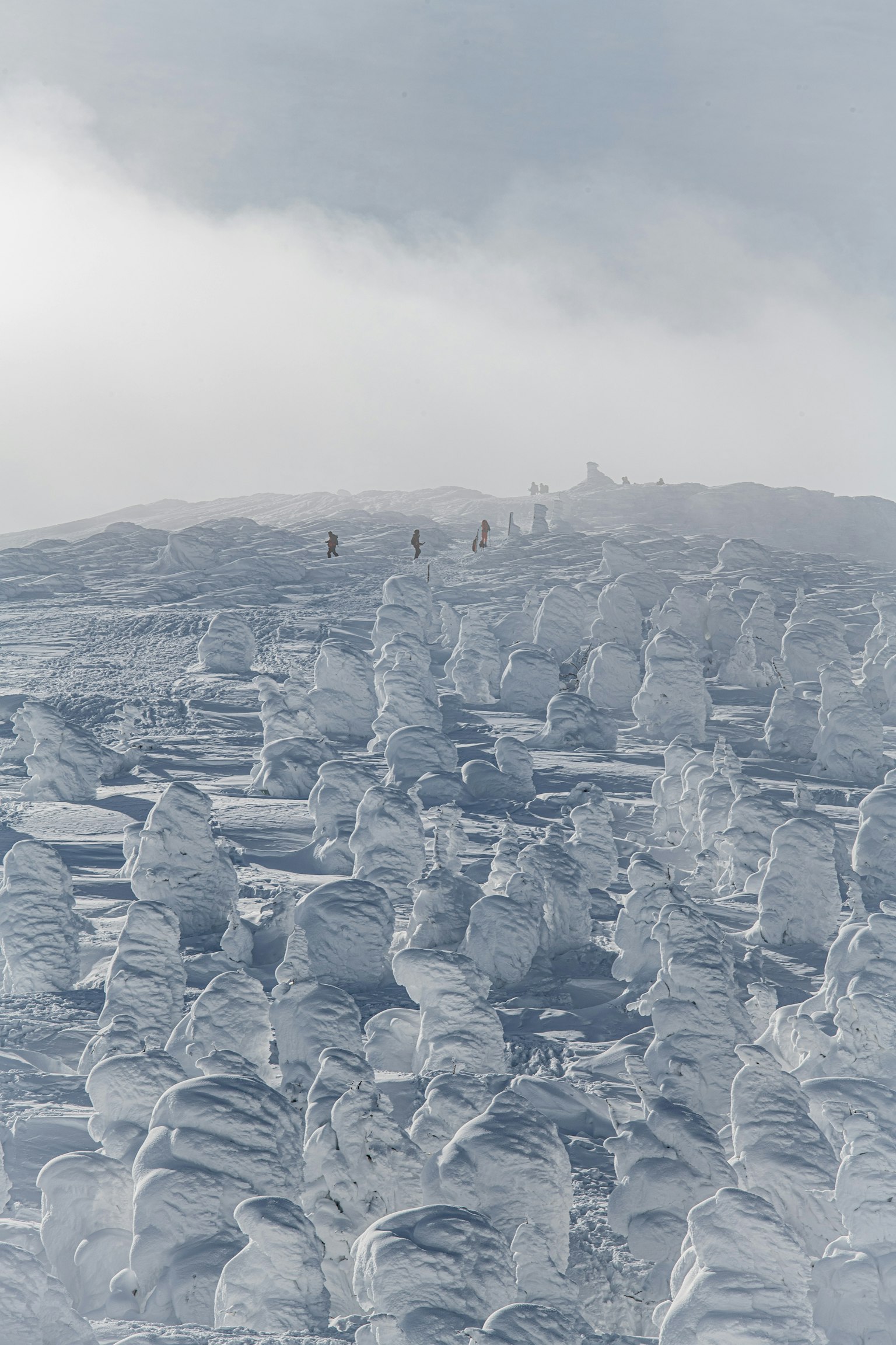 Schneebedeckte Landschaft mit Eisskulpturen und Menschen auf dem Gipfel des Berges