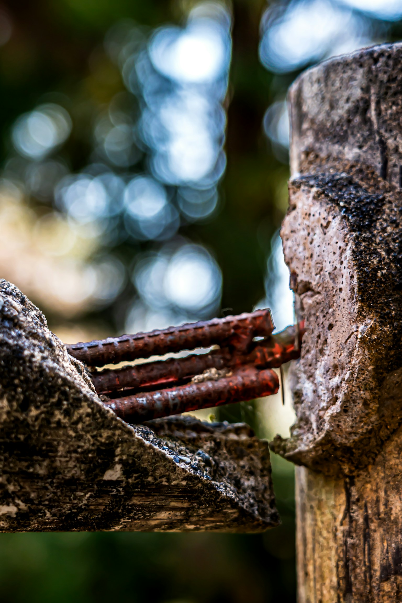 Gros plan sur une ancienne structure en béton avec des barres d'armature rouillées exposées