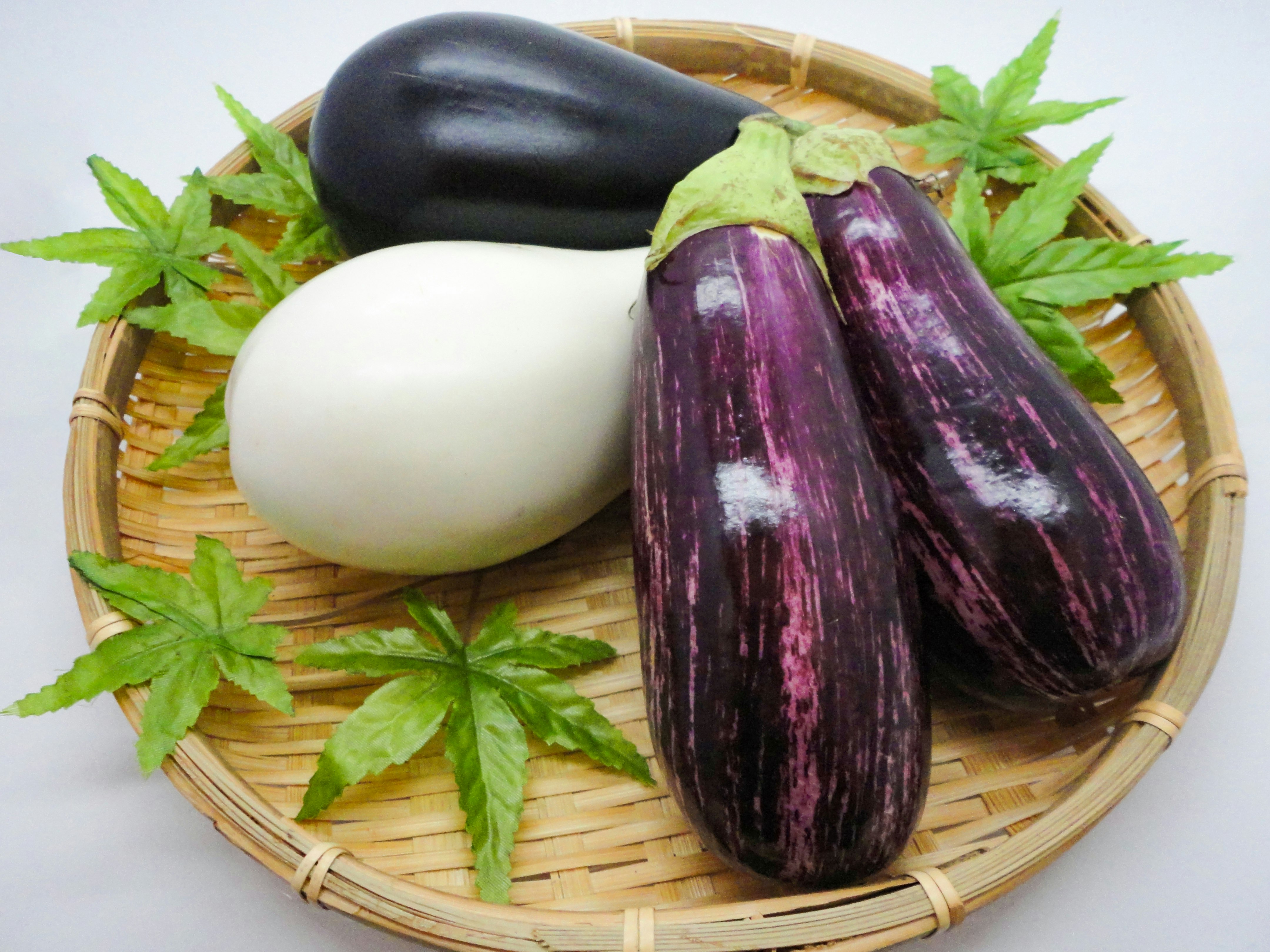 竹籃裡的茄子和白色蔬菜，紫蘇葉