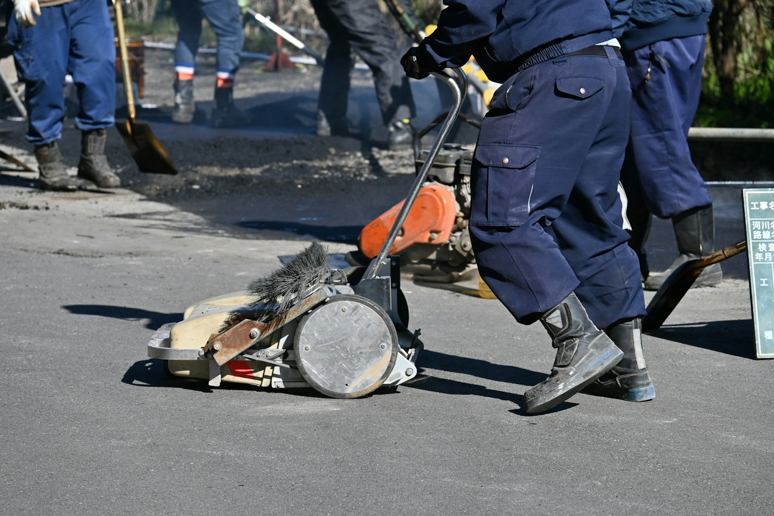 Arbeiter reparieren eine Straße mit einem Betonschneider