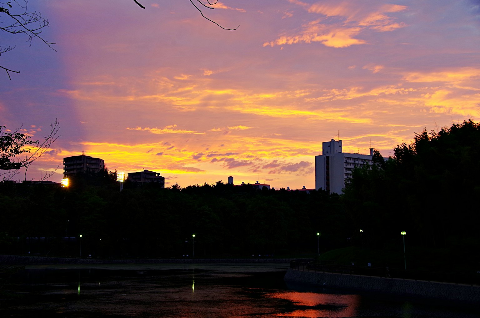 Silhouette of buildings against a vibrant sunset sky