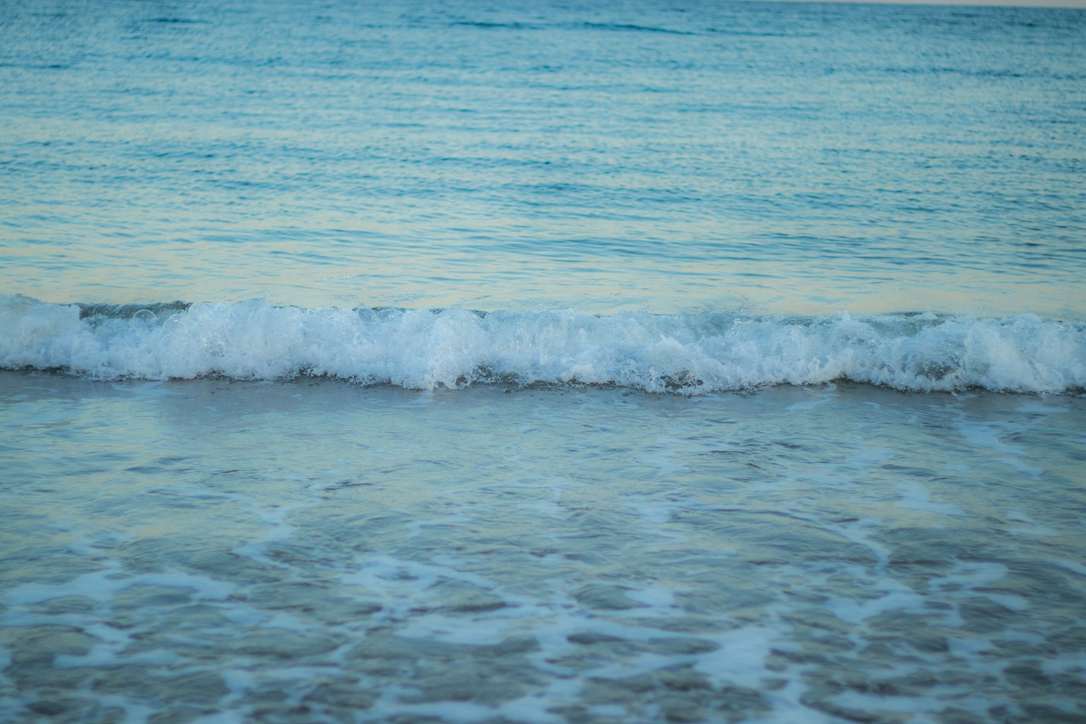 Calm ocean waves gently rolling onto the shore