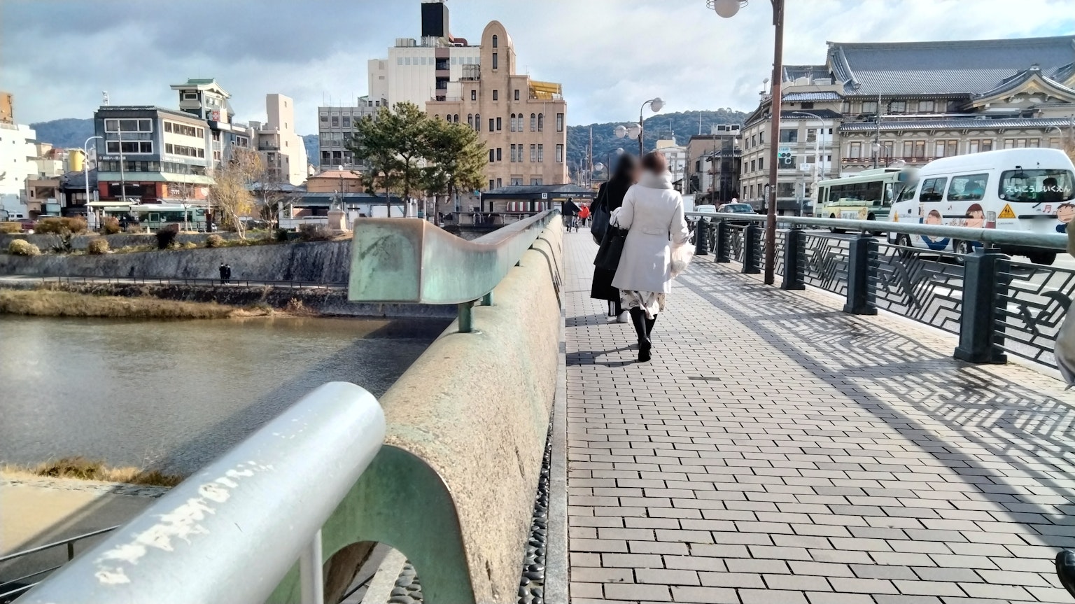 현대 건물과 함께 강변 산책로를 걷는 사람들