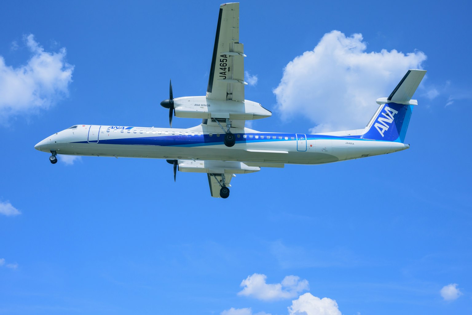 ANA propeller plane flying under a blue sky