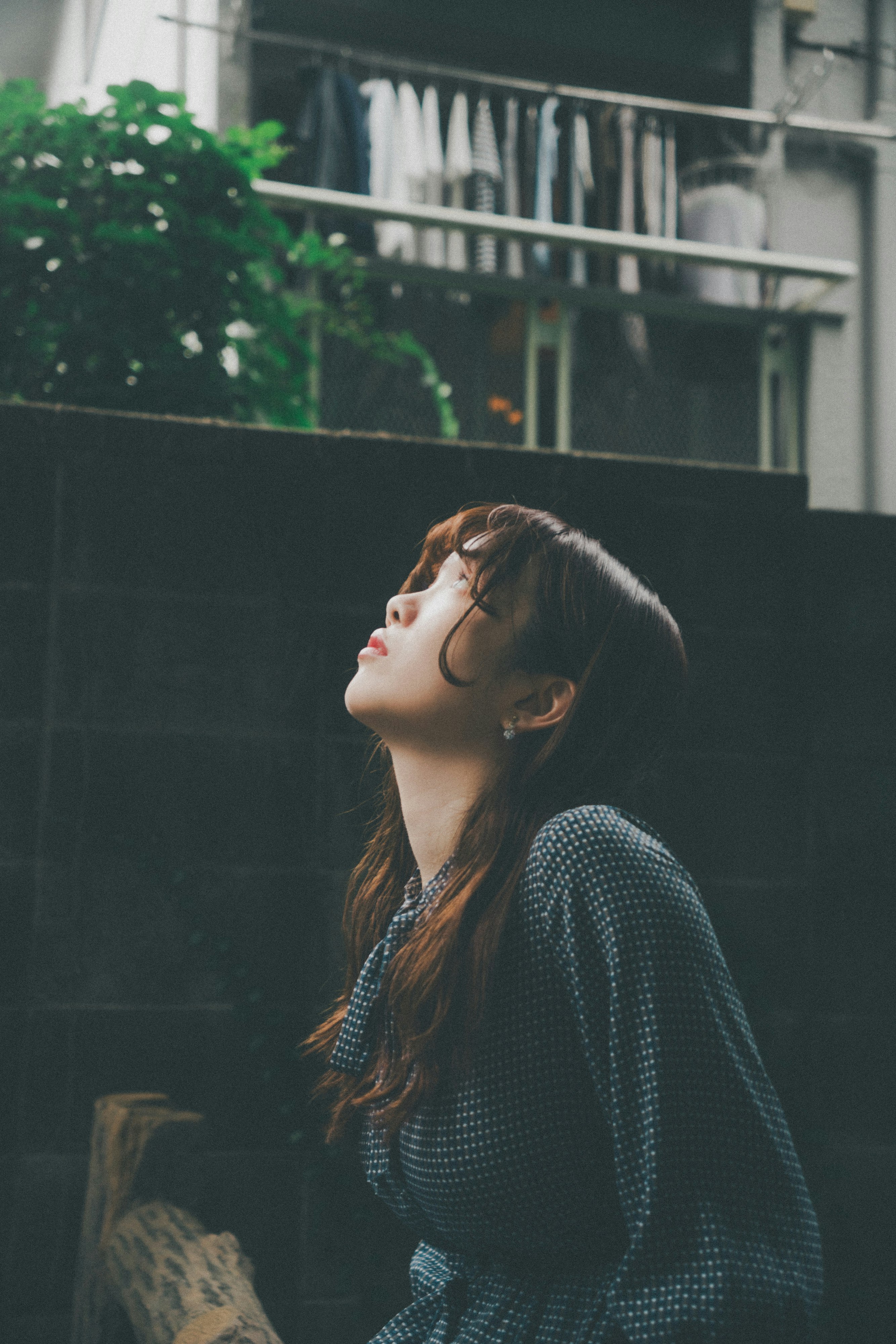 阳台栏杆前抬头的女性