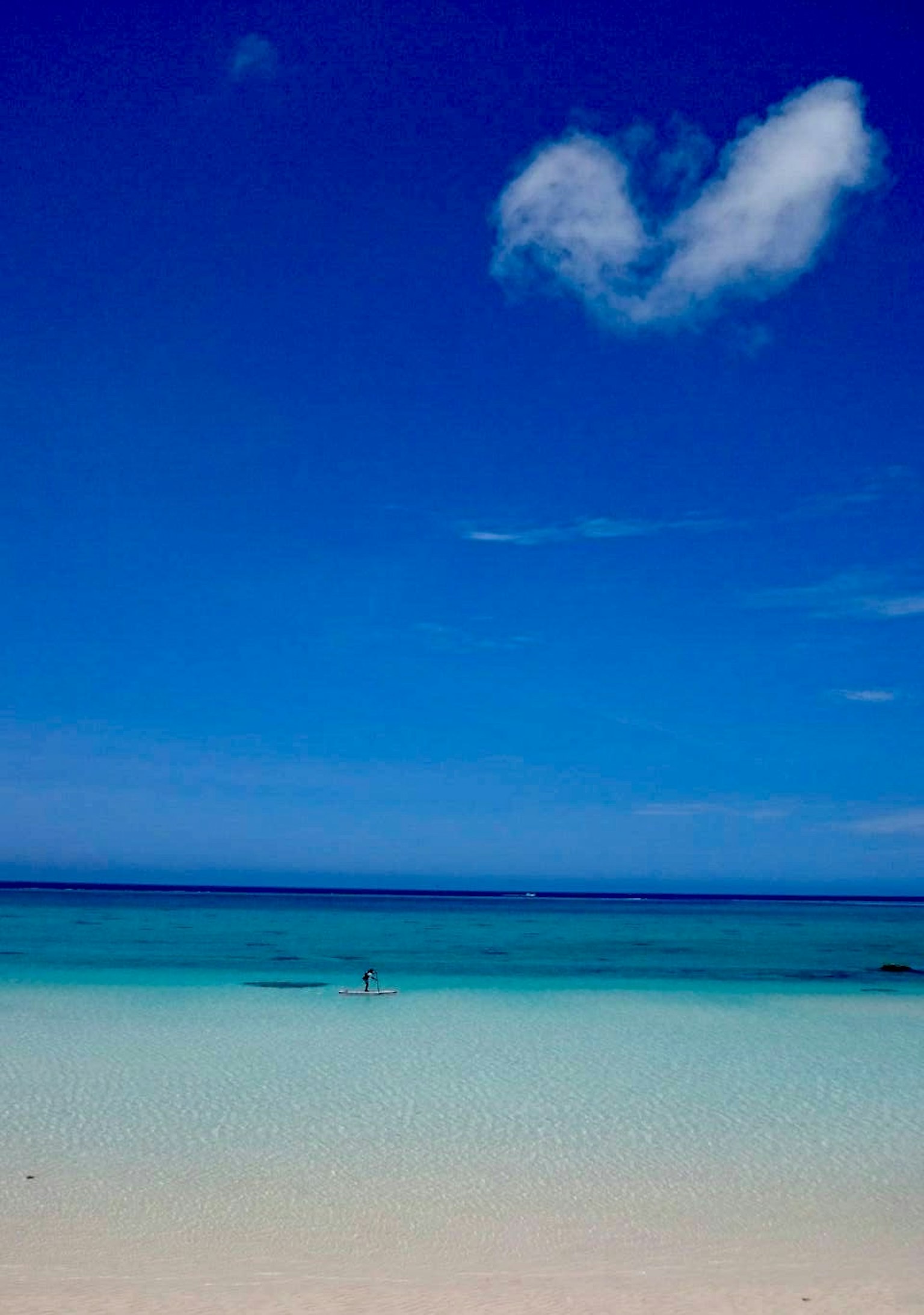 Pemandangan pantai dengan langit biru dan air turquoise yang jernih