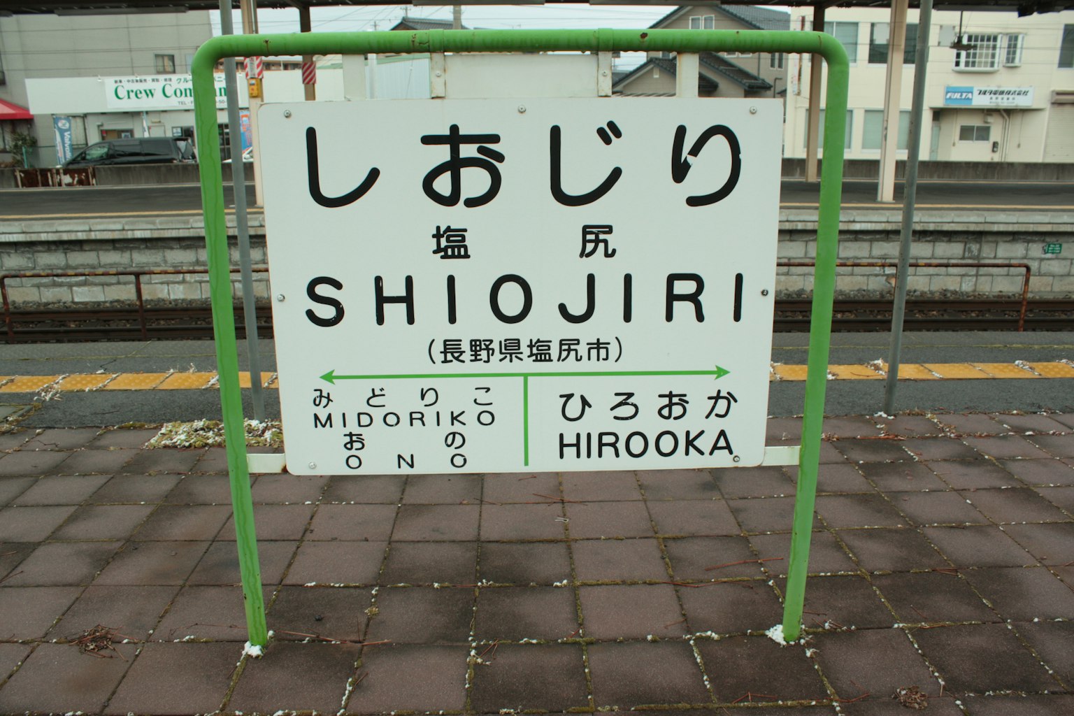 Cartel de la estación de Shiojiri marco verde fondo blanco texto negro