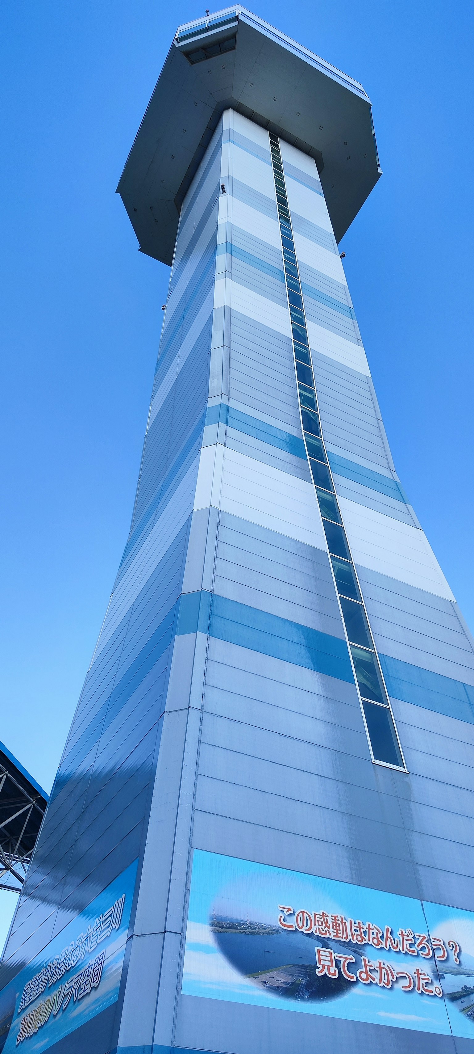 Tall striped tower in blue and white against a clear sky