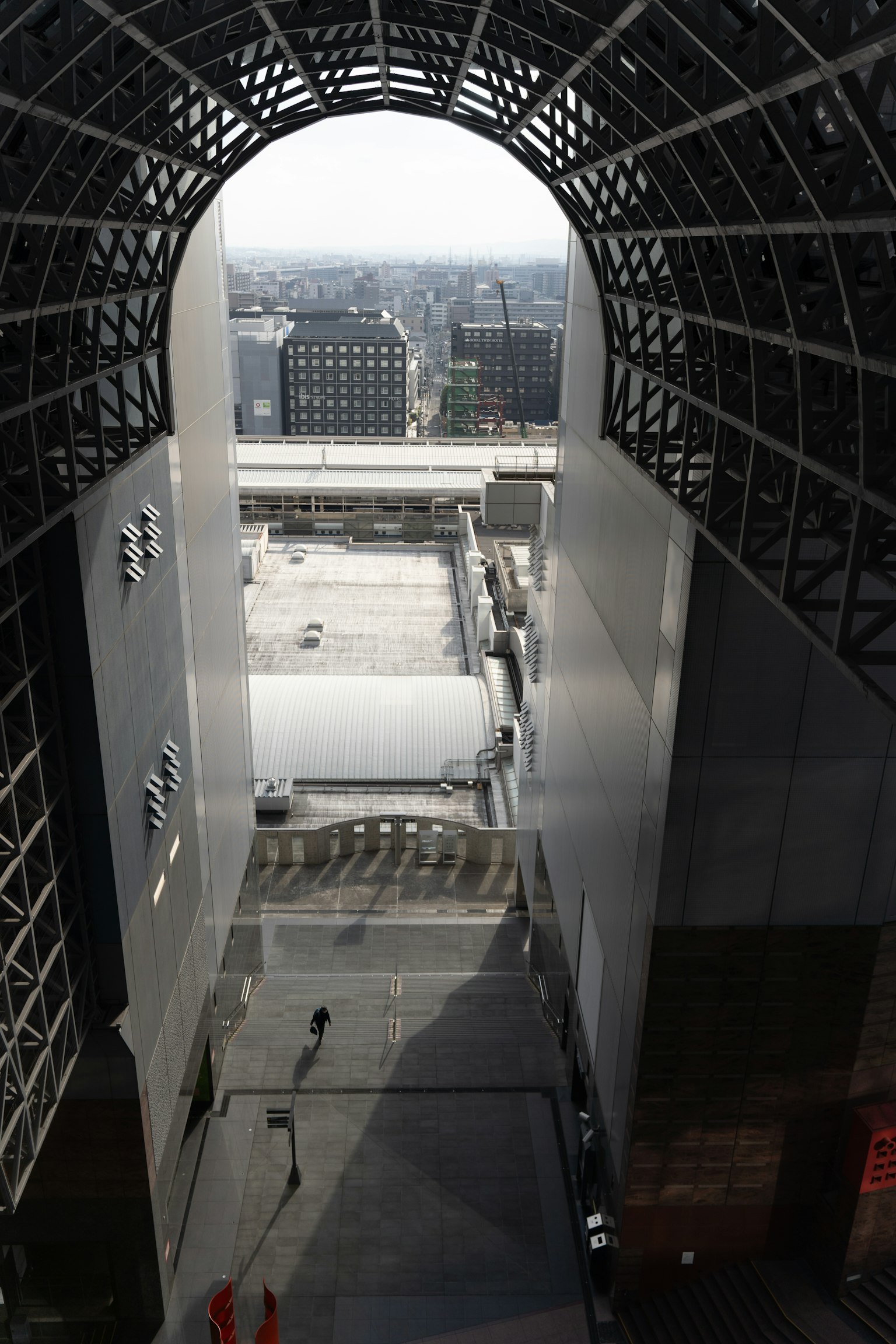 Blick von innen auf ein modernes Gebäude mit einer breiten Bogenöffnung nach draußen
