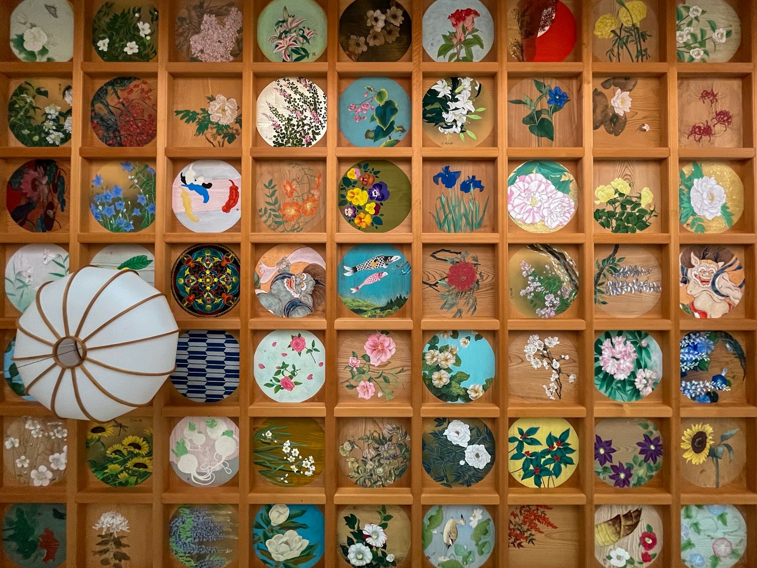 一面美丽的墙上展示着排列在木格子中的多彩刺绣作品