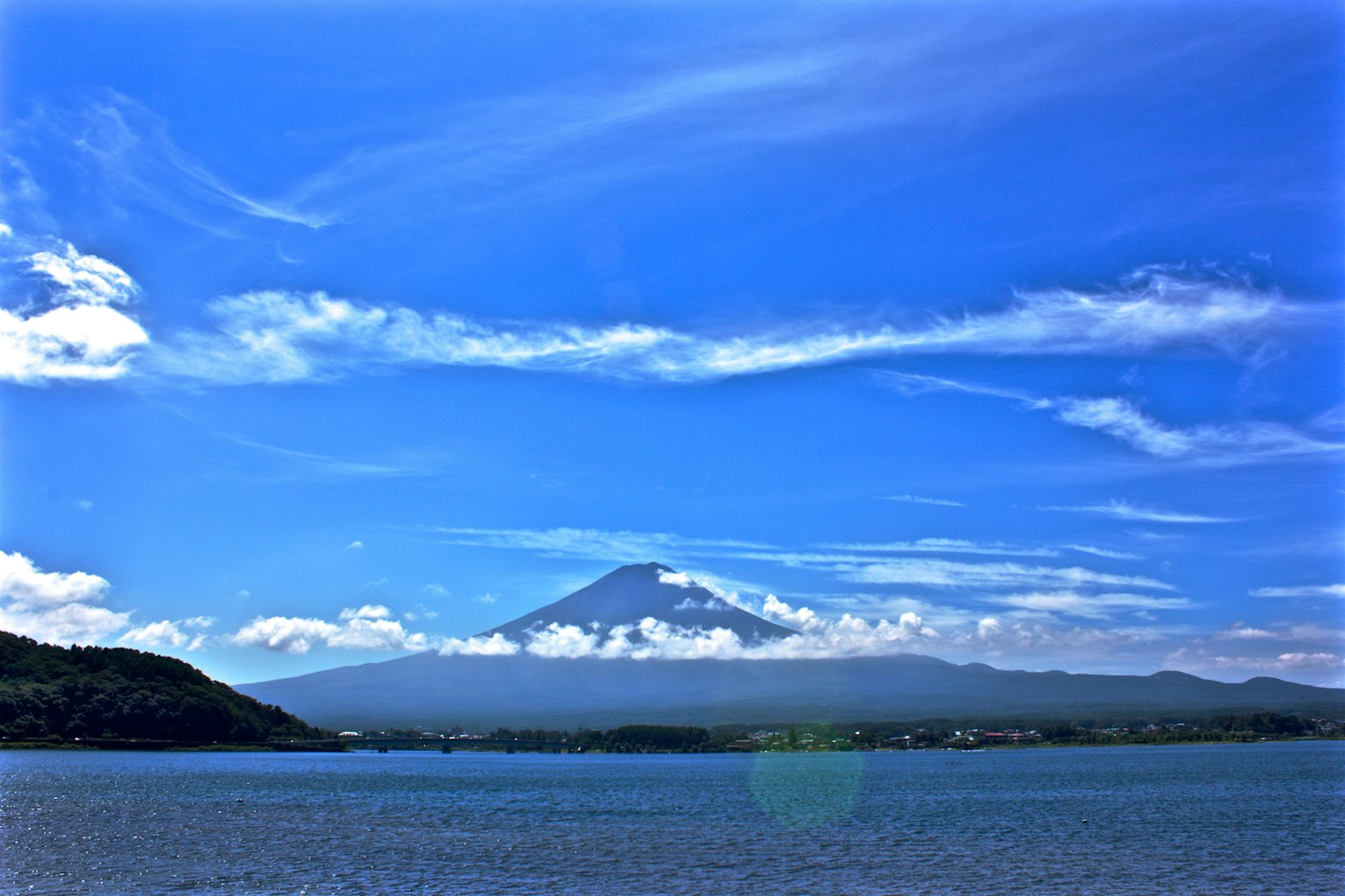 ทิวทัศน์ที่สวยงามพร้อมภูเขาฟูจิใต้ท้องฟ้าสีฟ้าและเมฆสีขาว