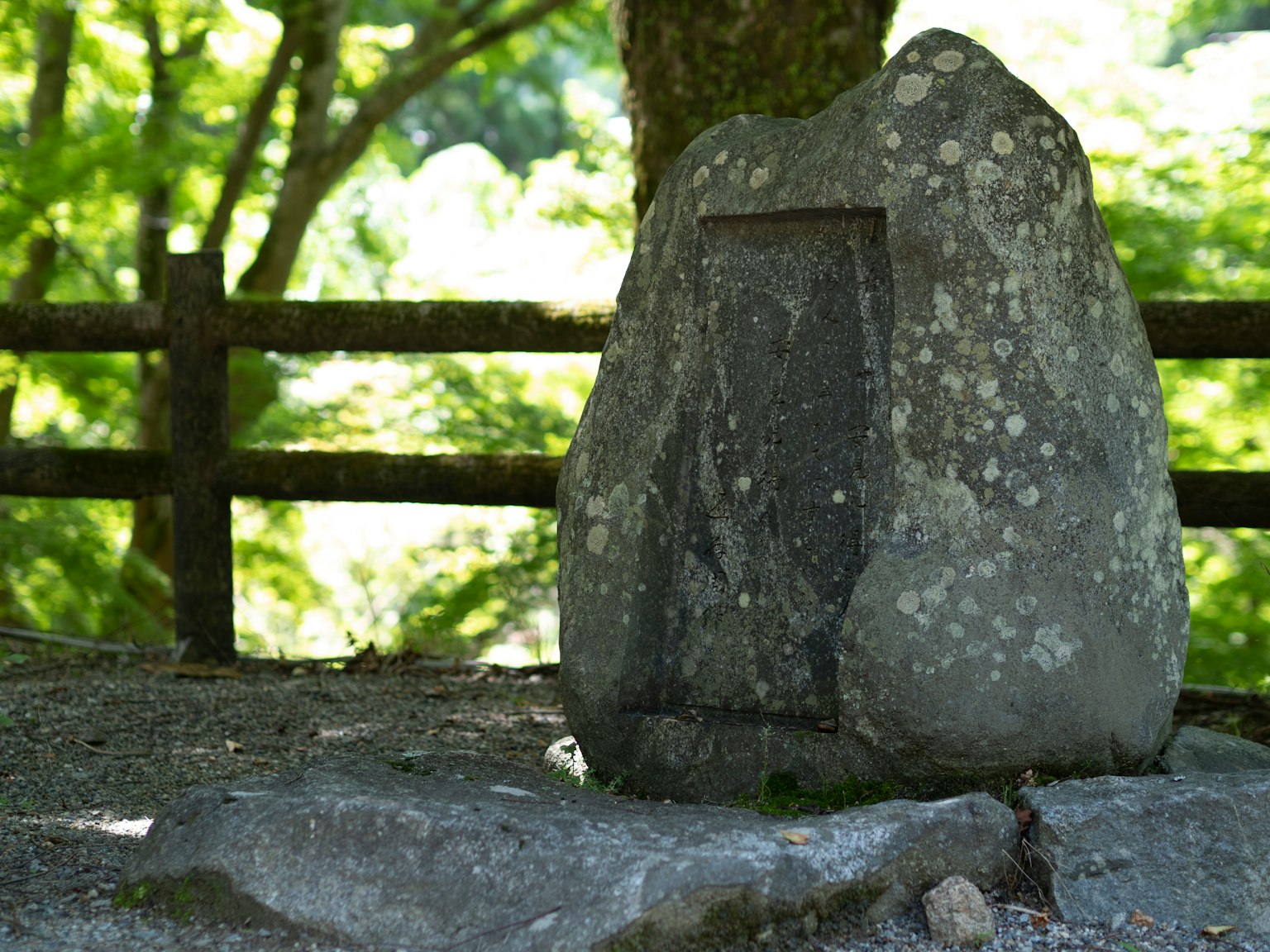 Monumento de piedra cubierto de musgo contra un fondo verde