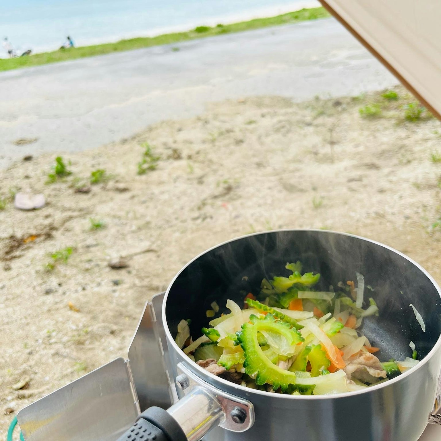 Panci berisi sayuran yang sedang dimasak di pantai