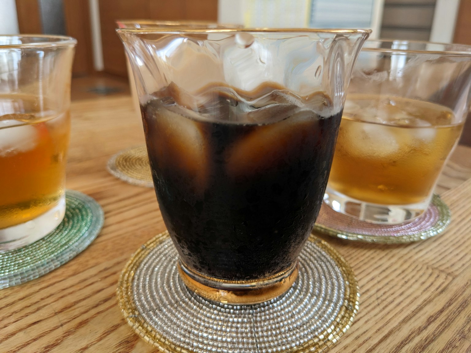 Set gelas dengan minuman es di atas meja kayu
