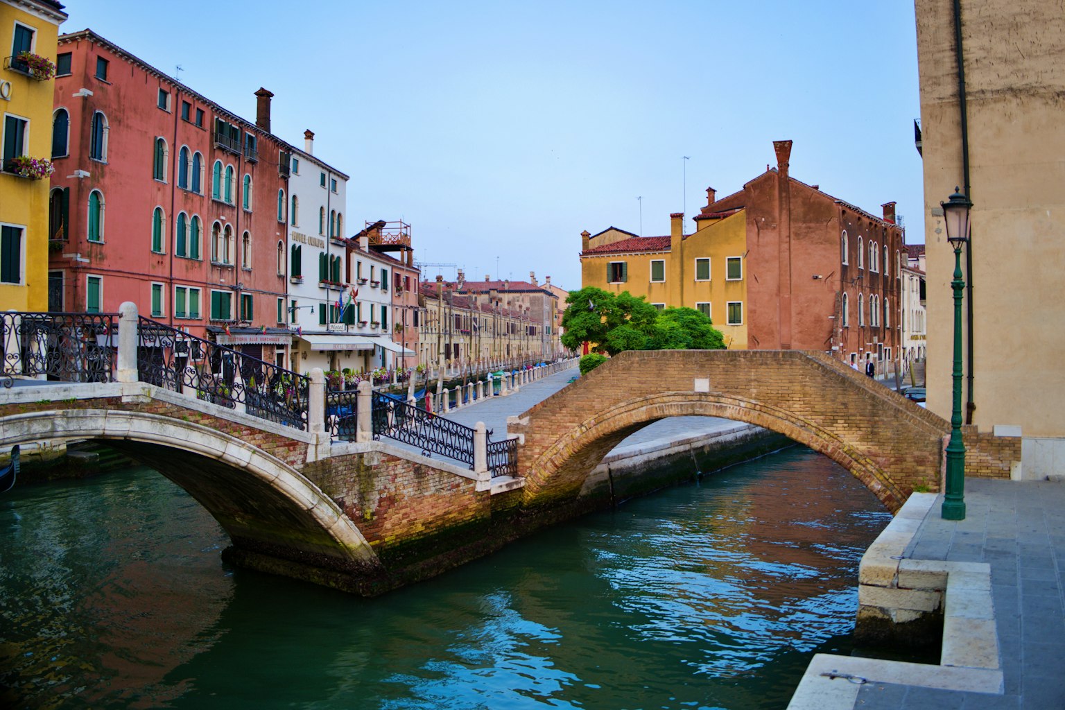 Scenic view of a canal in Venice with colorful buildings and a stone bridge