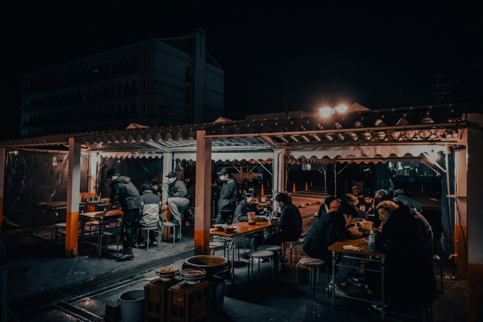 ผู้คนที่รับประทานอาหารที่ร้านขายของข้างถนนในเวลากลางคืน
