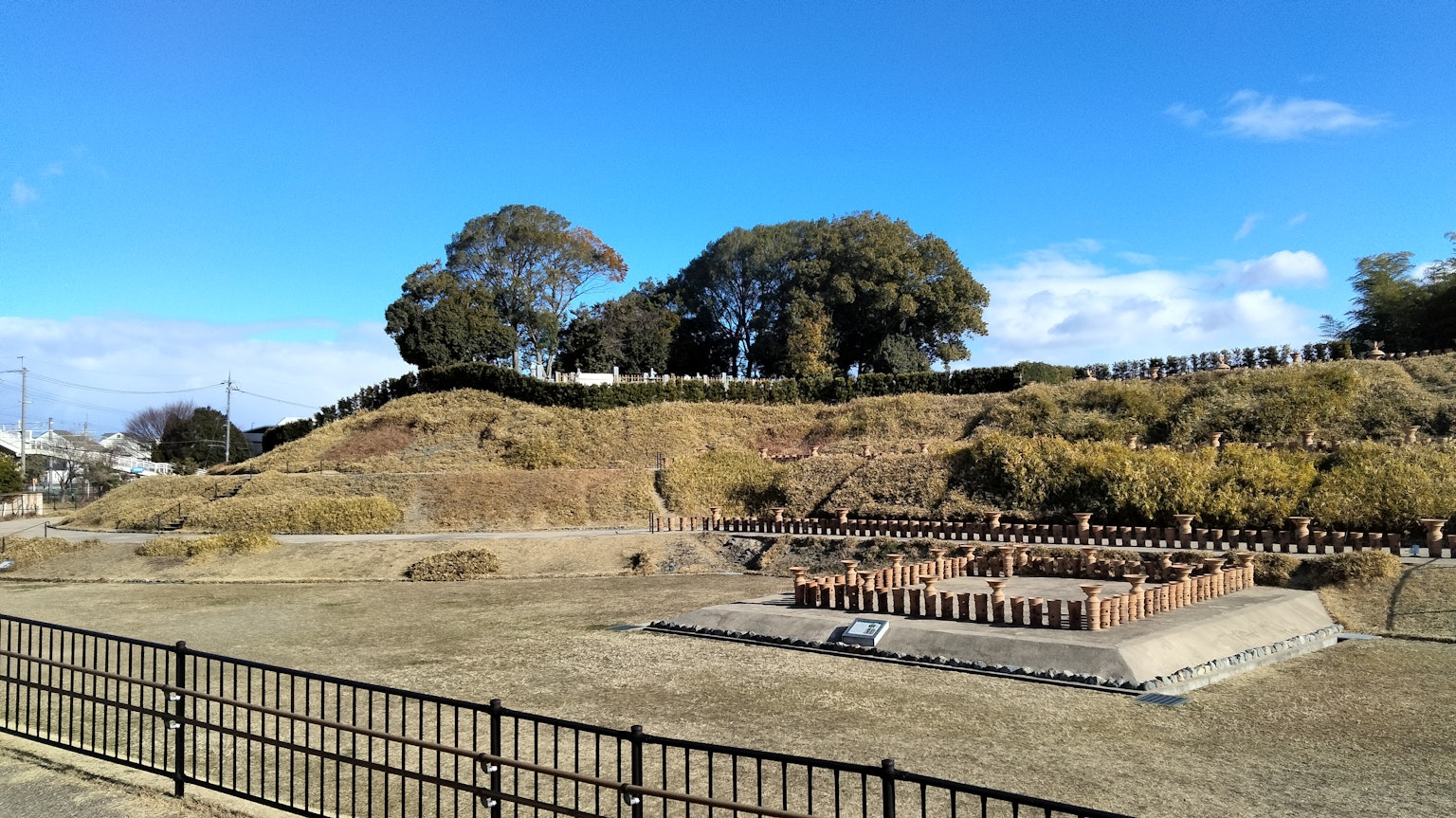 Amplia vista de un sitio arqueológico con cielo azul y árboles verdes