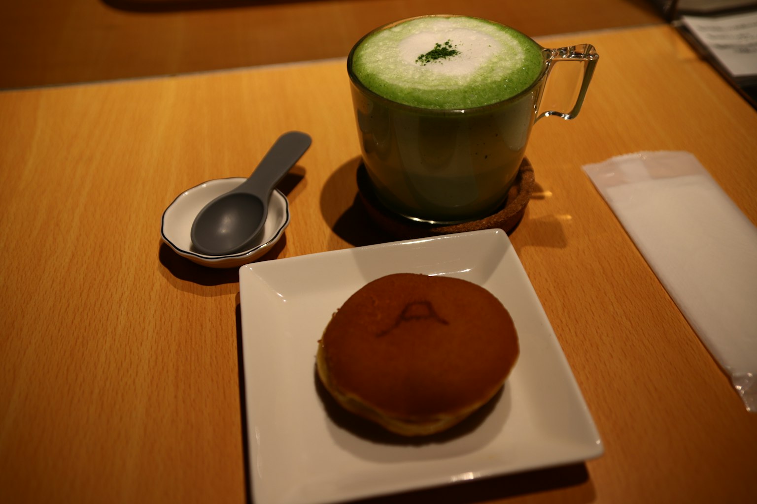 Un latte matcha e un dolce giapponese su un piatto su un tavolo di legno