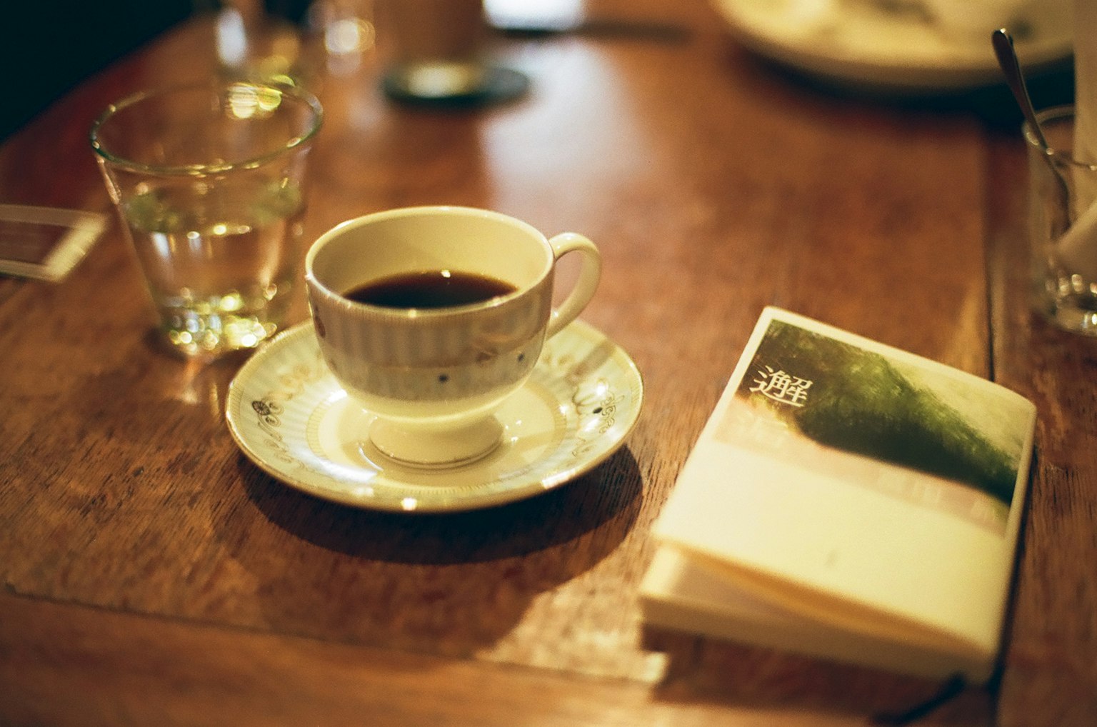 Coffee cup on a wooden table with a notebook