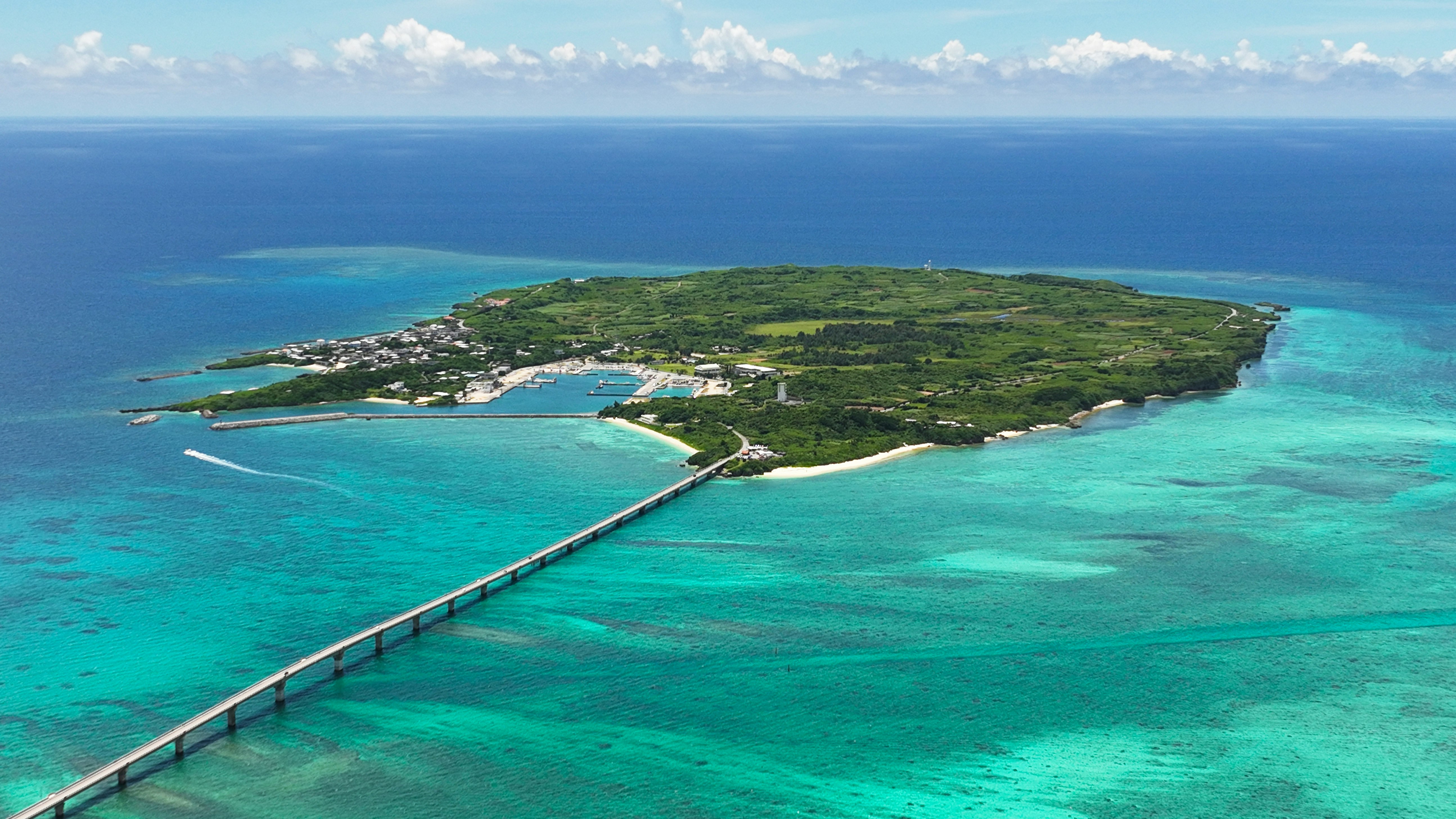 透明度の高い海と細い橋が続く小さな島の景色
