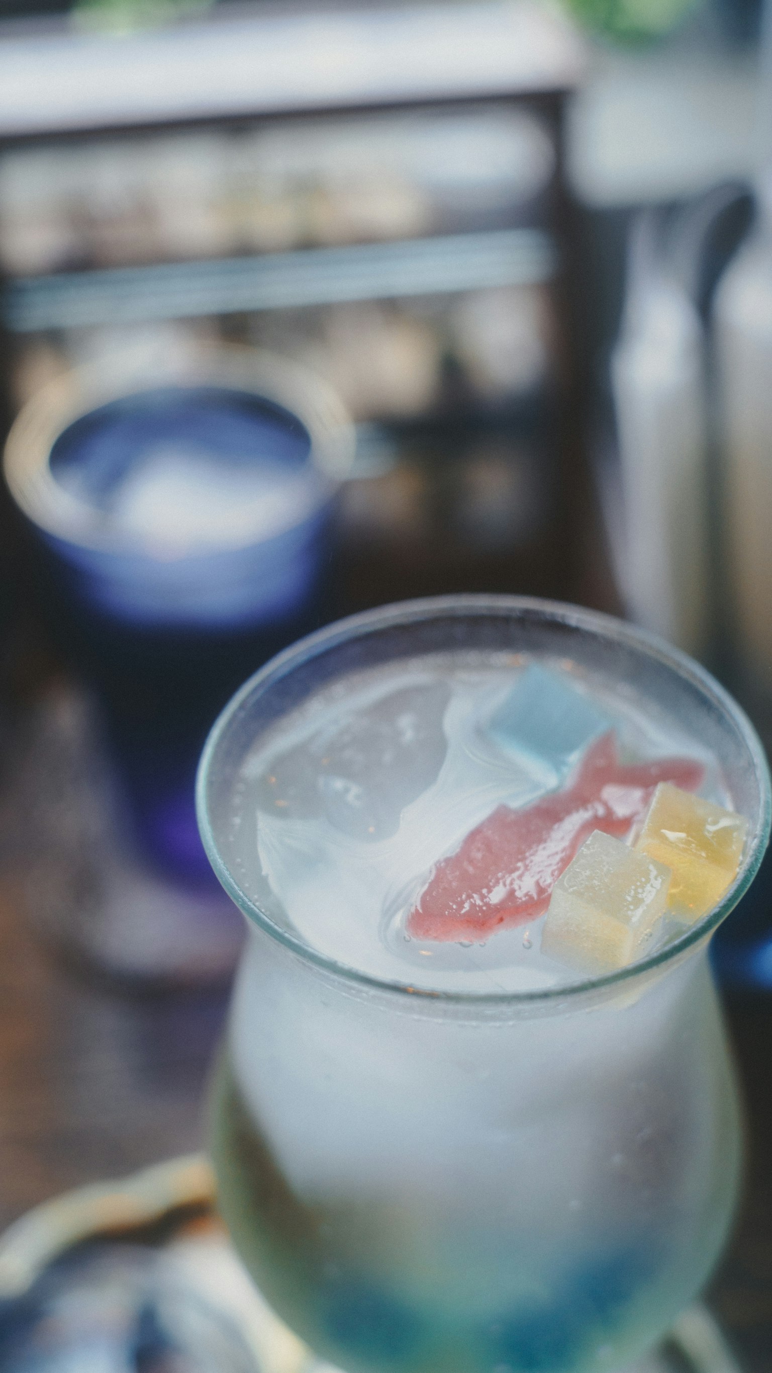 カラフルな飲み物が氷とフルーツのトッピングと共にグラスに入っている