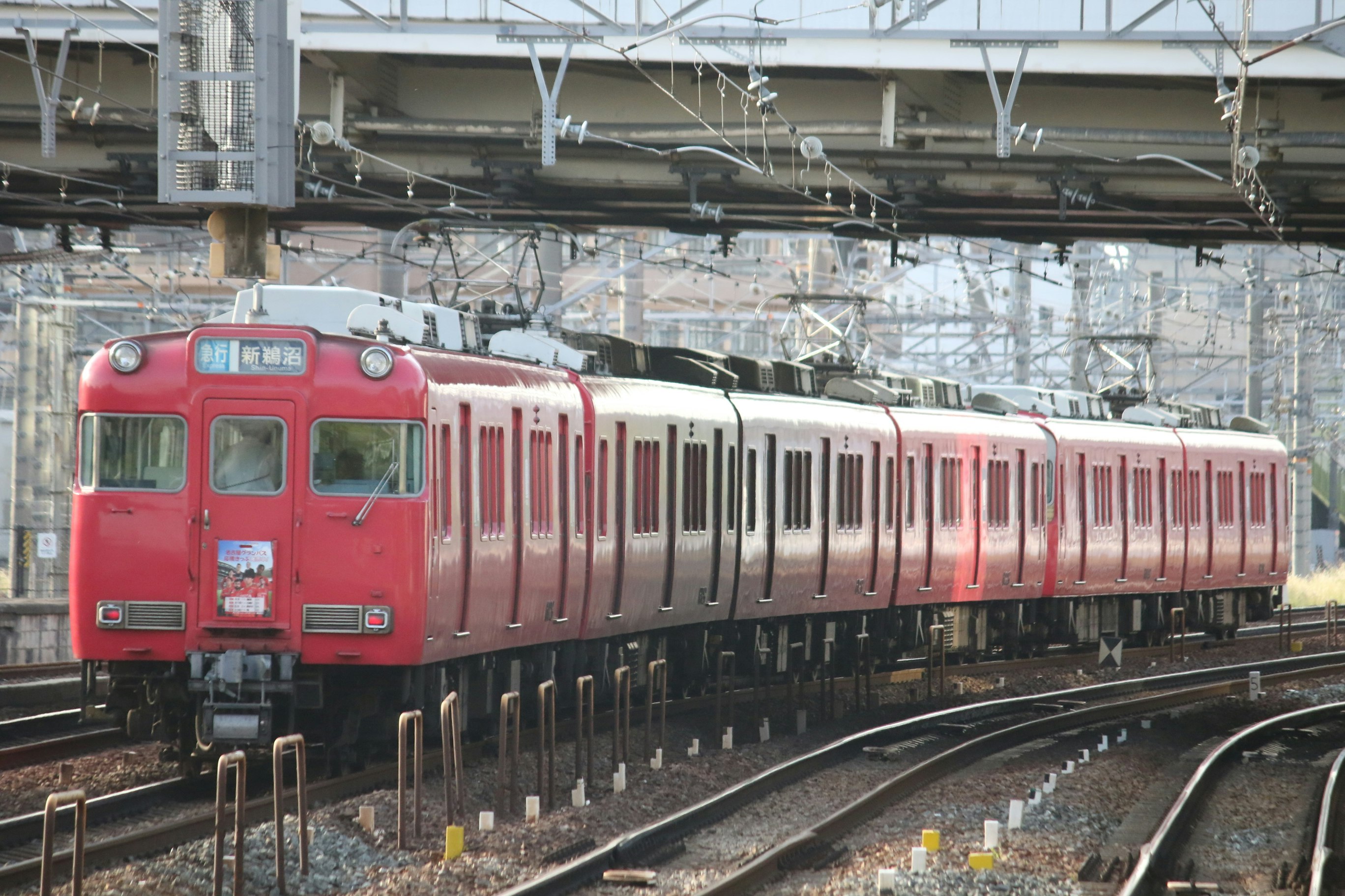 紅色列車車廂行駛在高架軌道上
