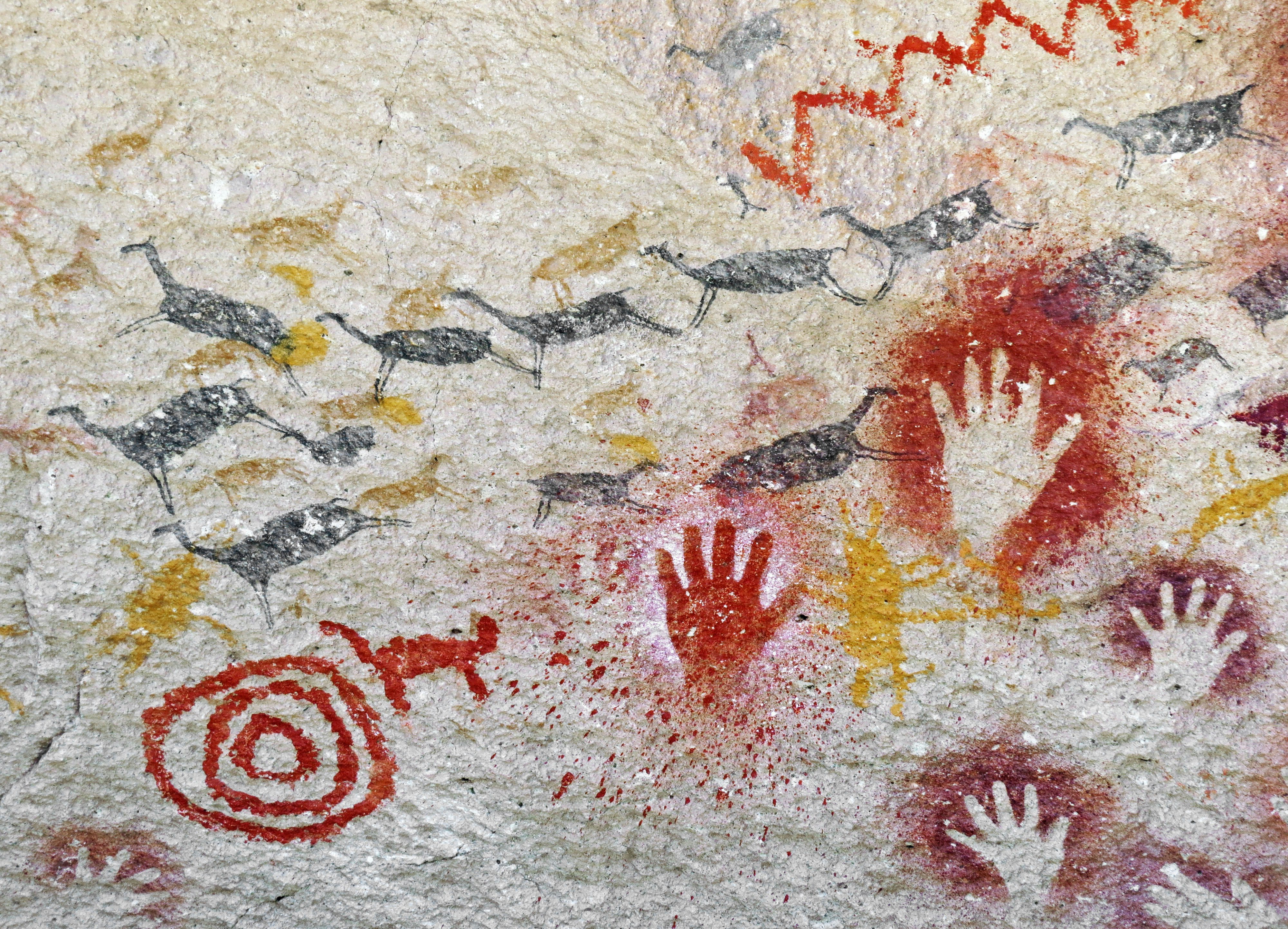 concrete wall with graffiti-style handprints and arrows