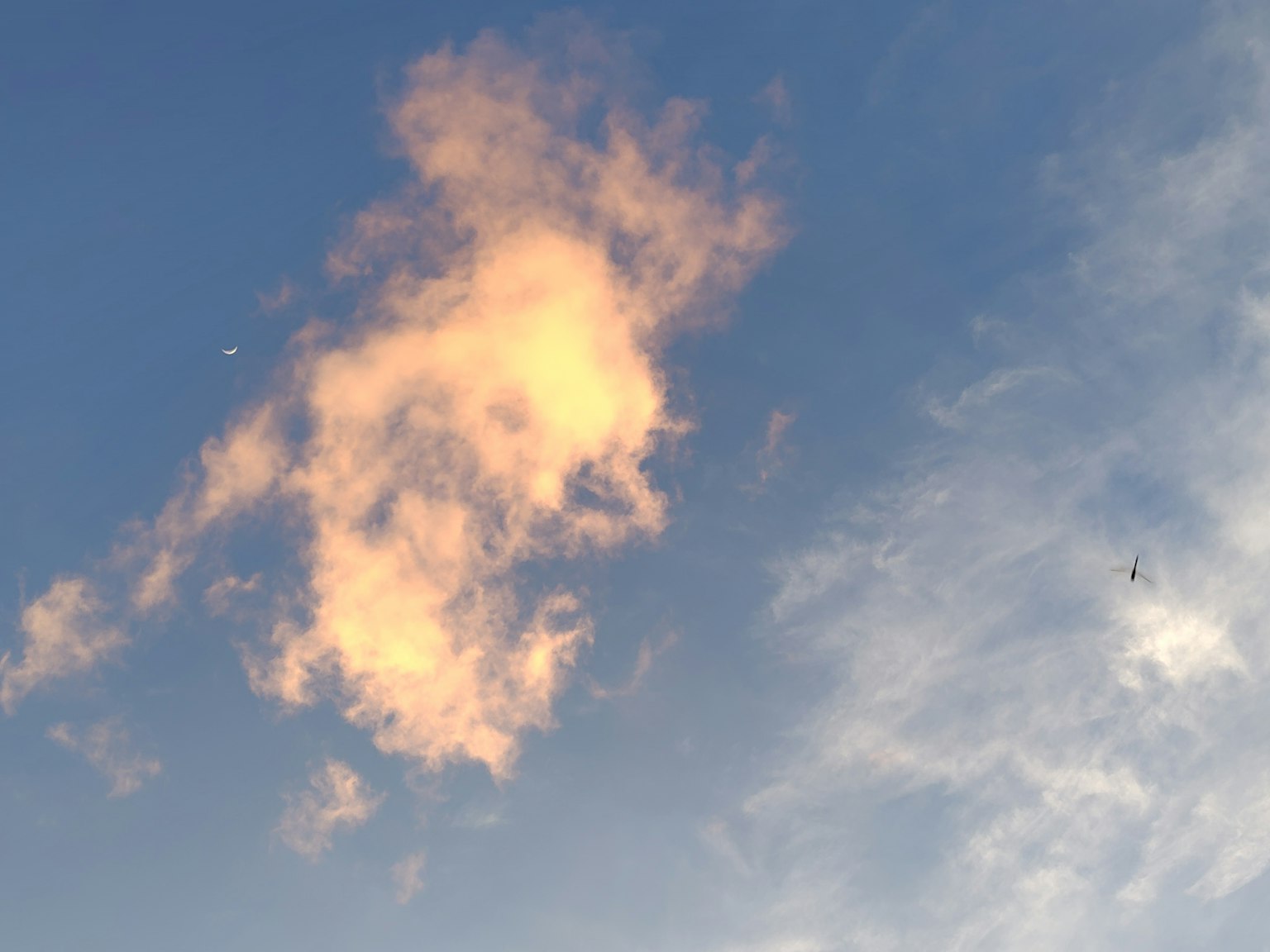 Sanfte orange Wolken vor einem blauen Himmel mit wispy weißen Wolken