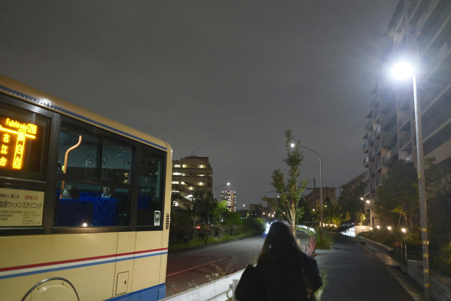 Un bus garé dans une rue de la ville la nuit avec une personne marchant