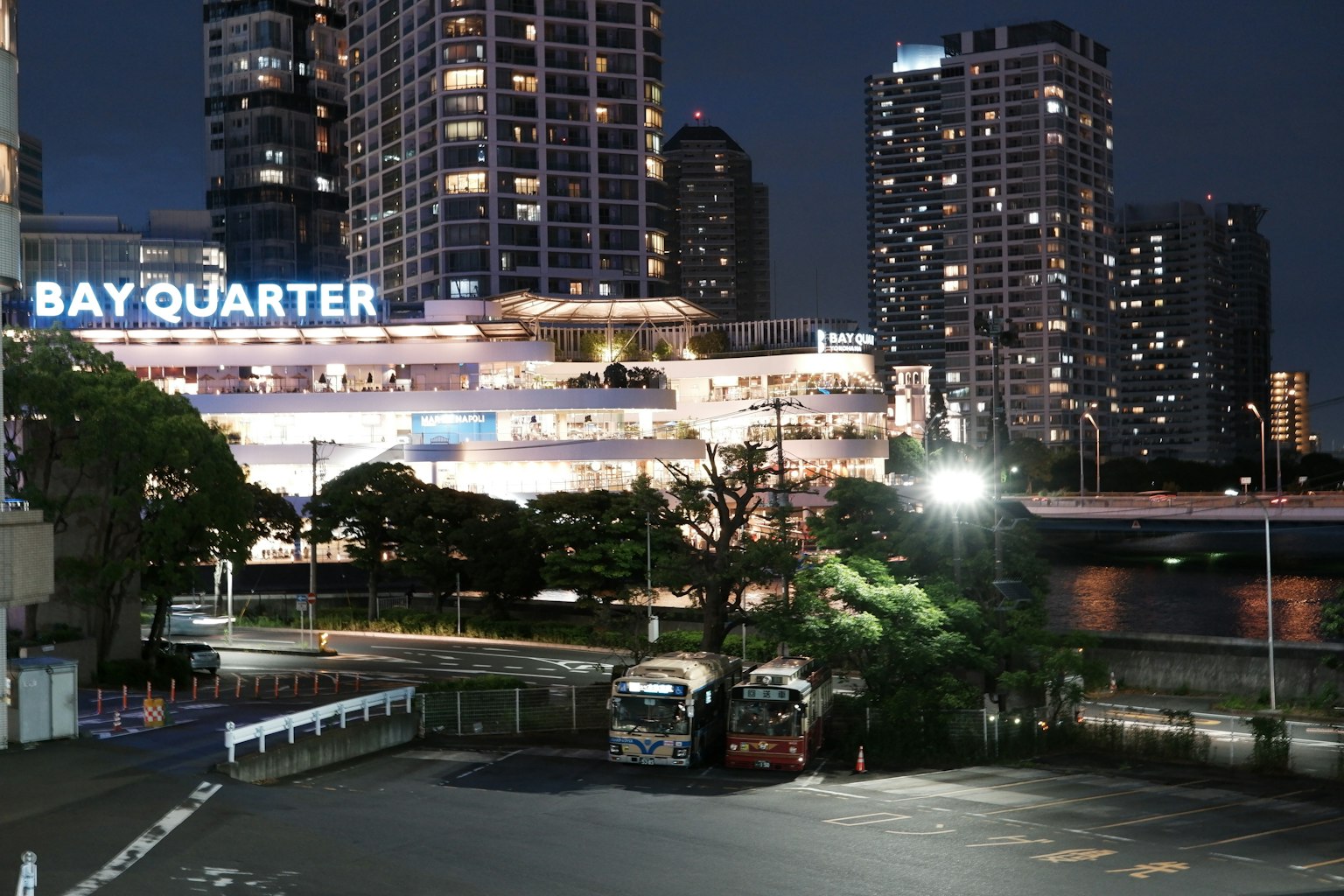 Pemandangan malam Bay Quarter dengan bangunan yang diterangi dan area parkir