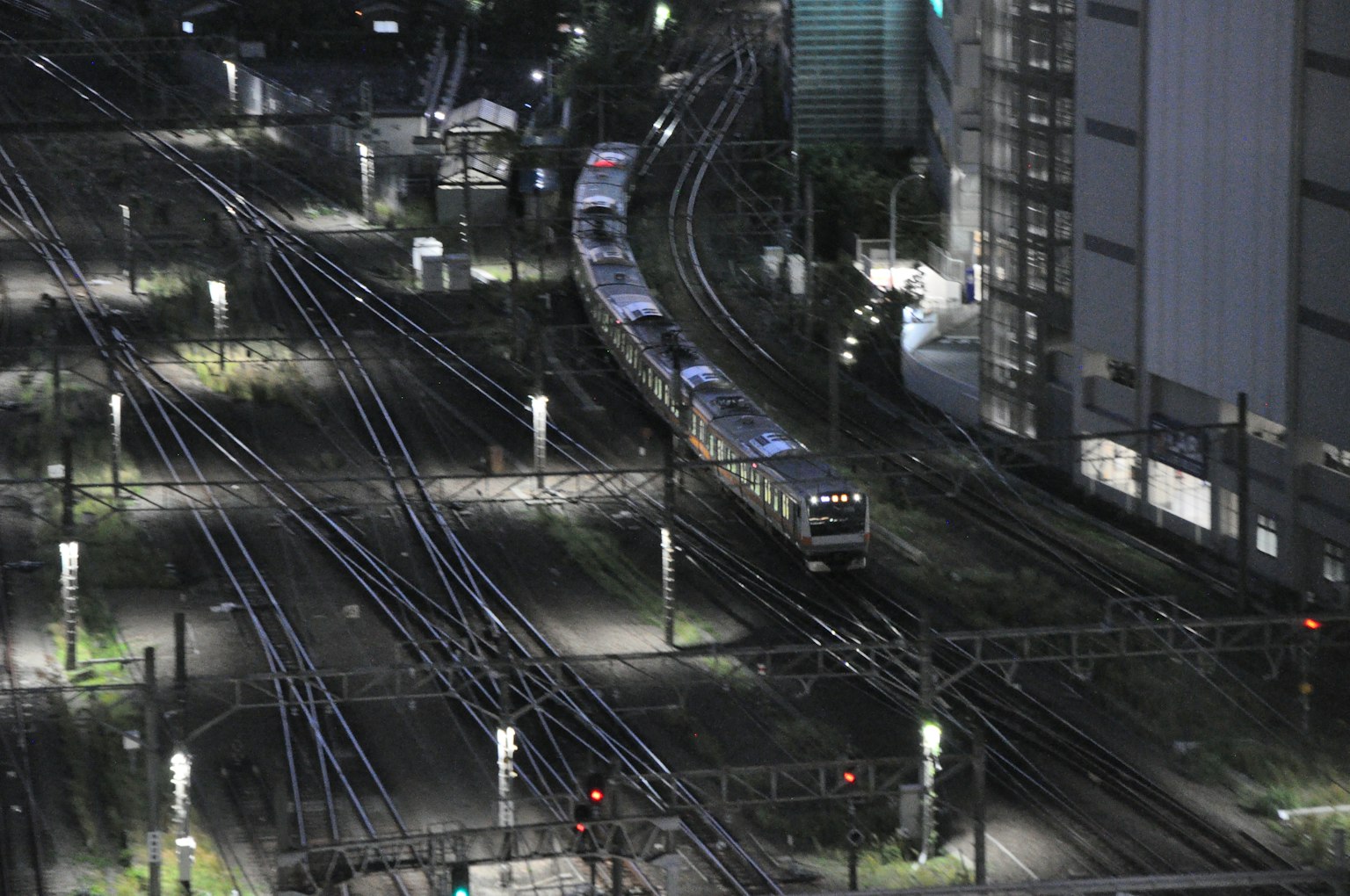 Scena notturna di binari con un treno curvo in movimento