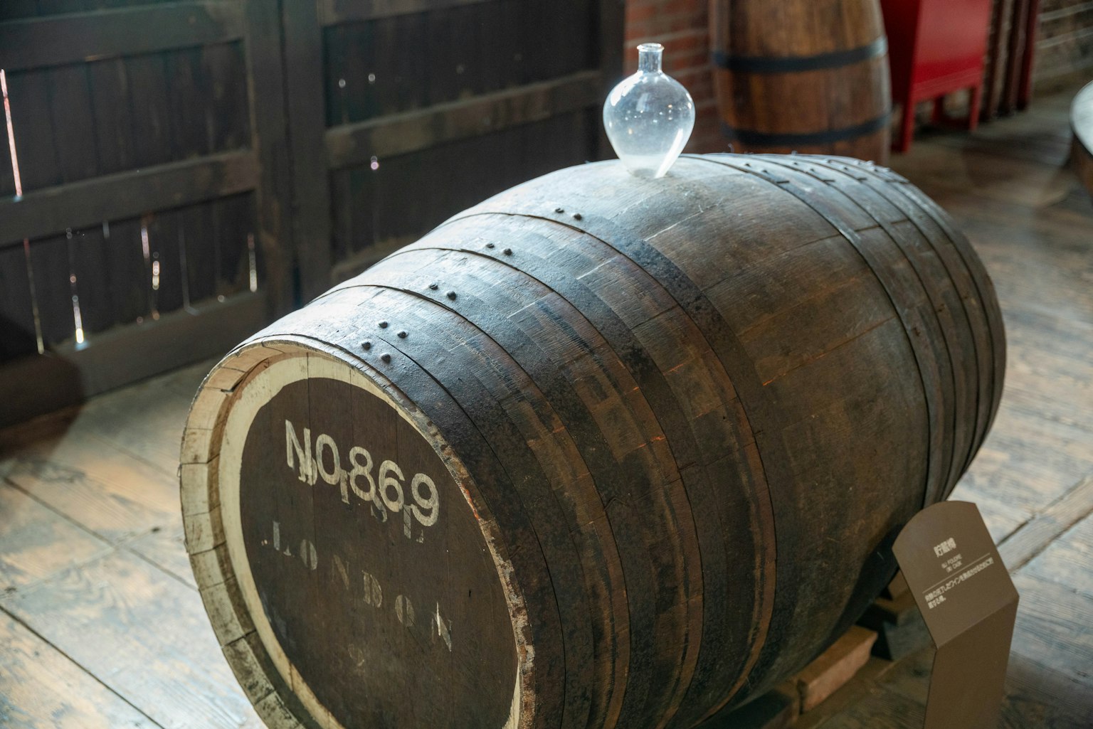 Ein Holzfass mit einer transparenten Flasche darauf