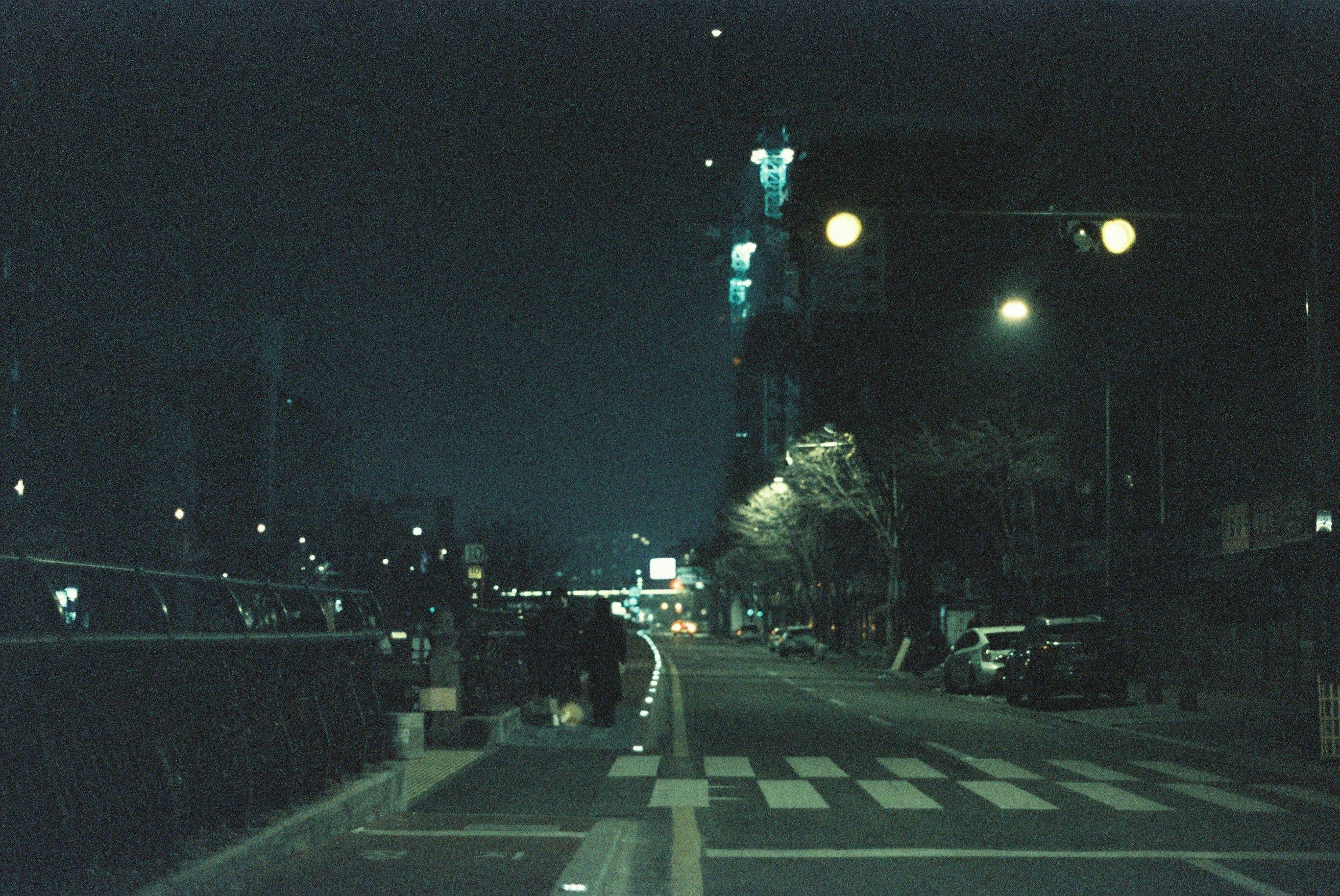calle nocturna con coches y una intersección urbana