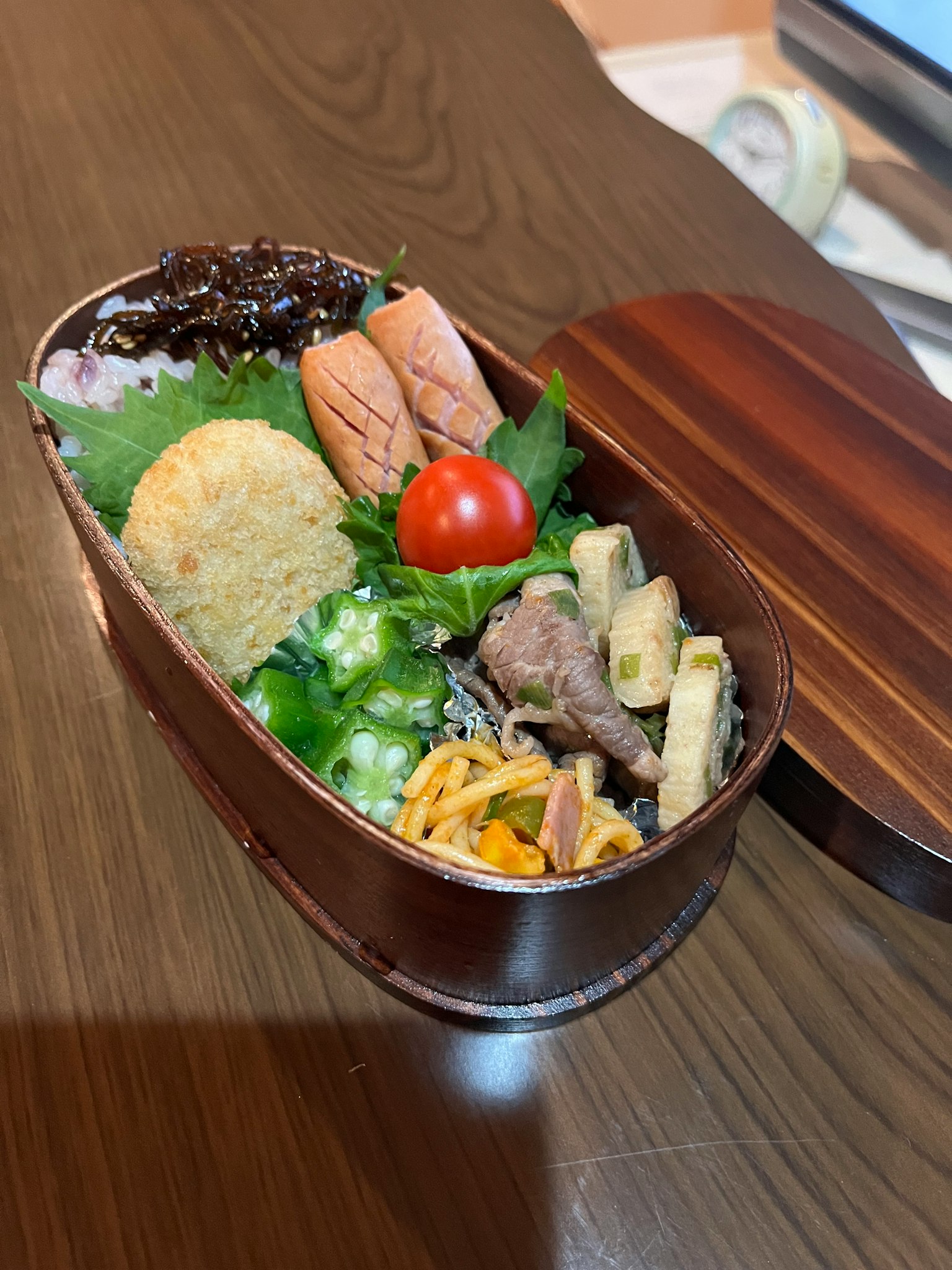 Une boîte à bento joliment présentée avec des ingrédients colorés
